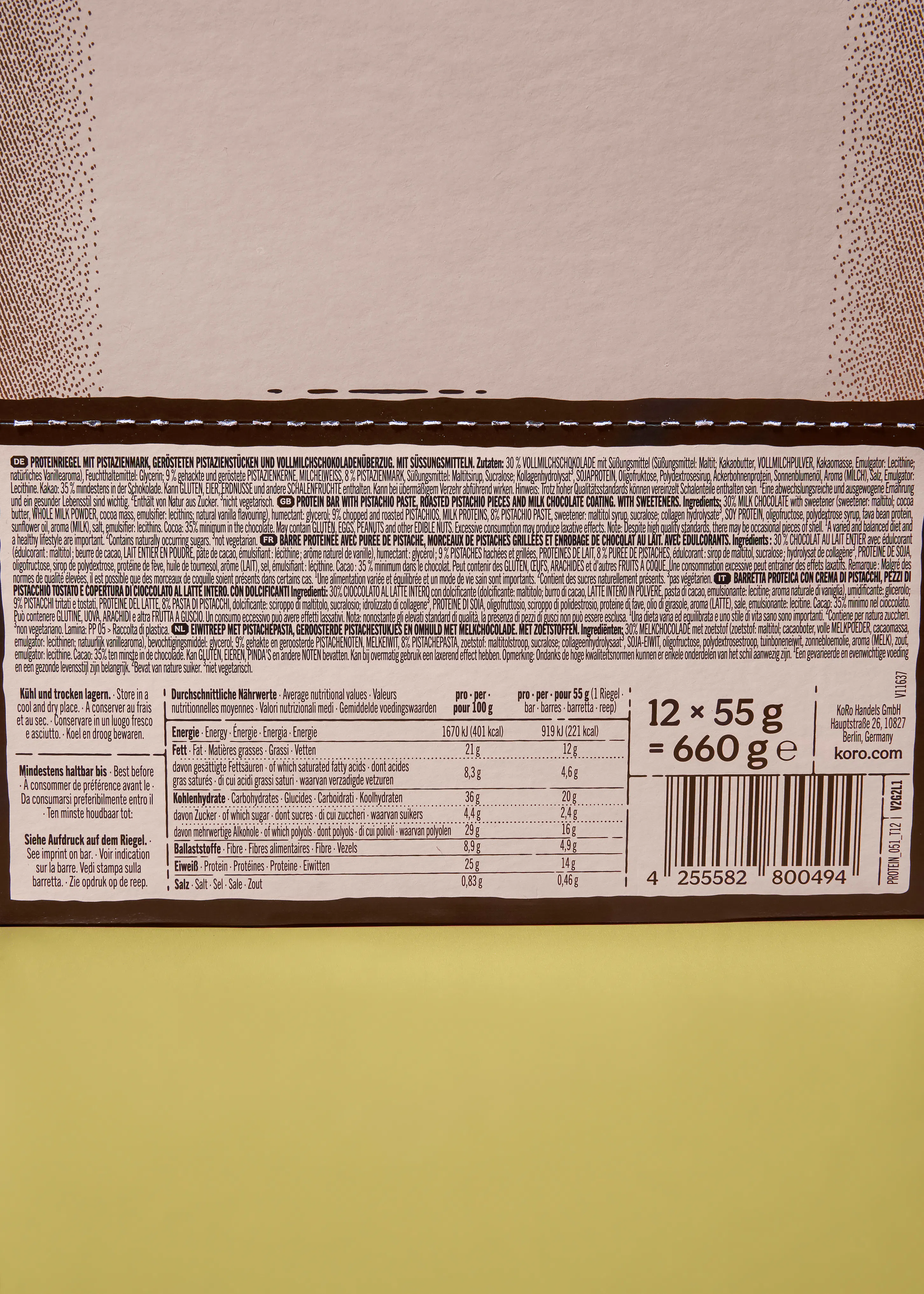 etichetta di un prodotto per una barretta proteica al pistacchio e cioccolato al latte, con informazioni nutrizionali, ingredienti multilingue, peso e codice a barre.