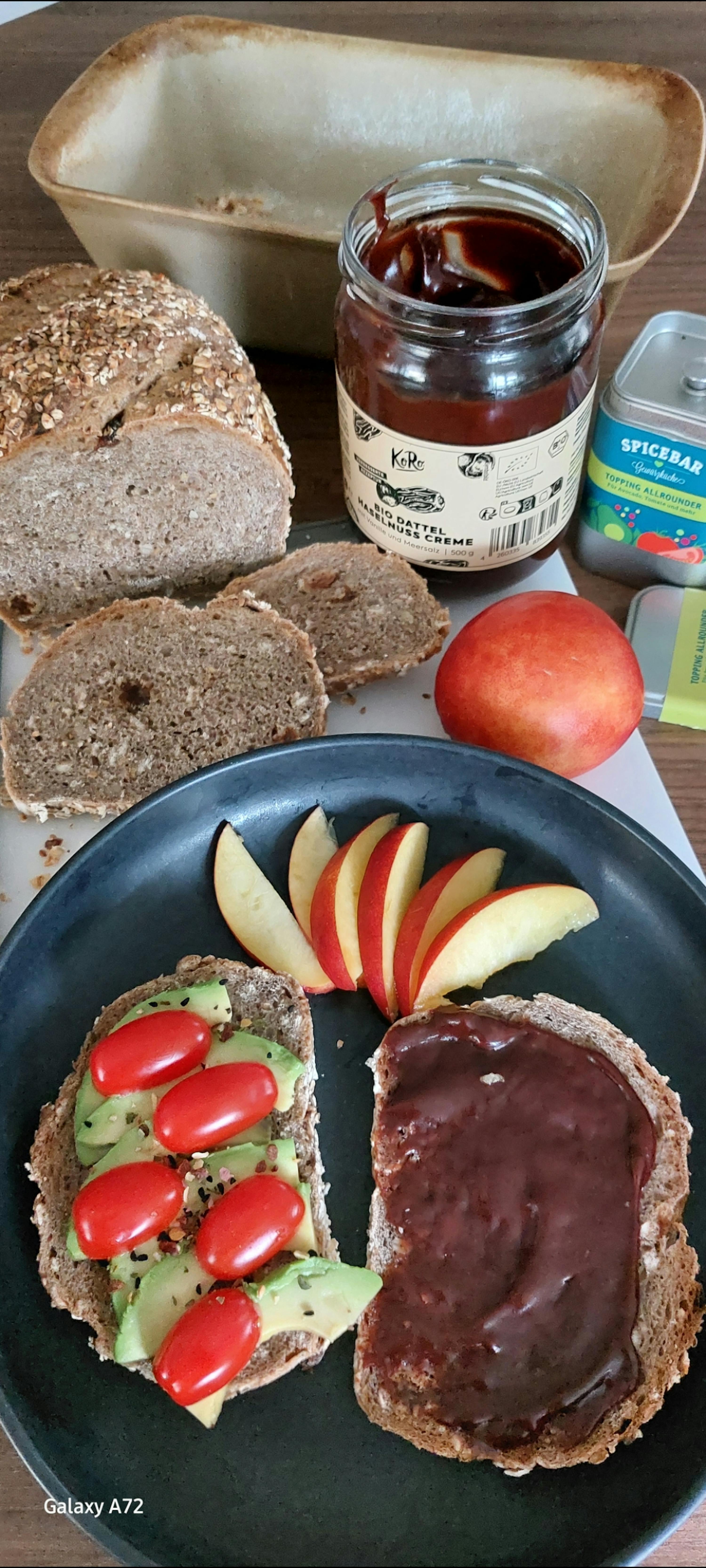 a galaxy a72 shows a sandwich with avocado tomatoes and apples