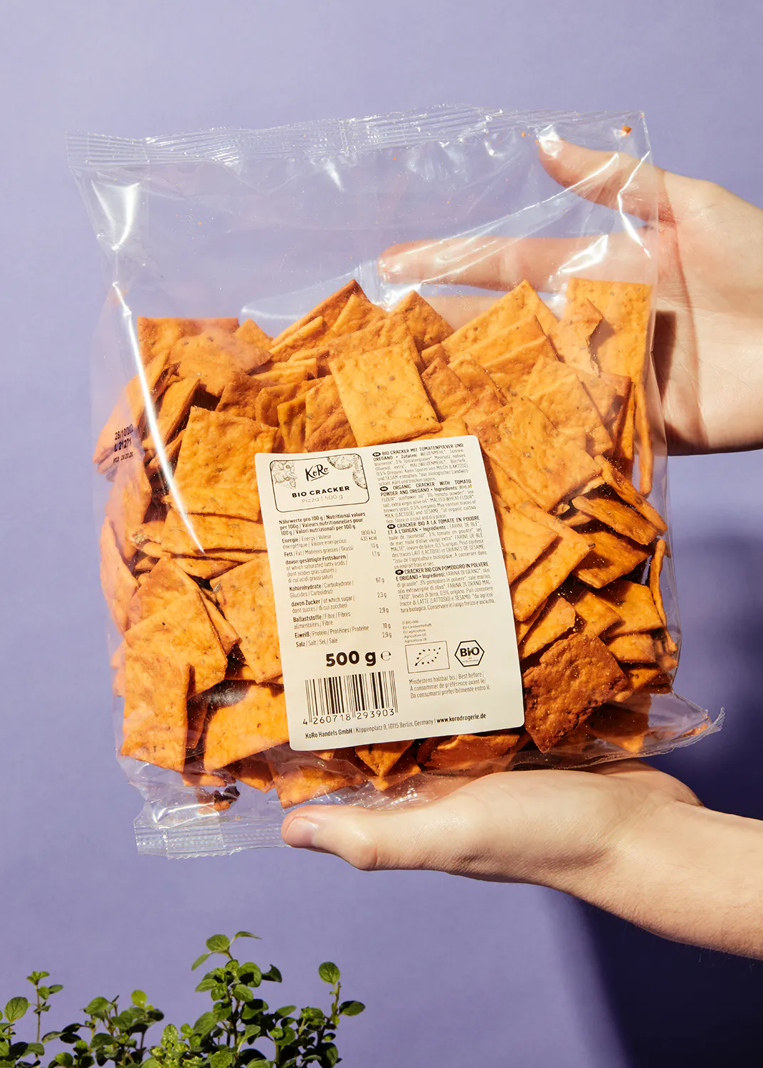 a person is holding a bag of bio crackers in their hands