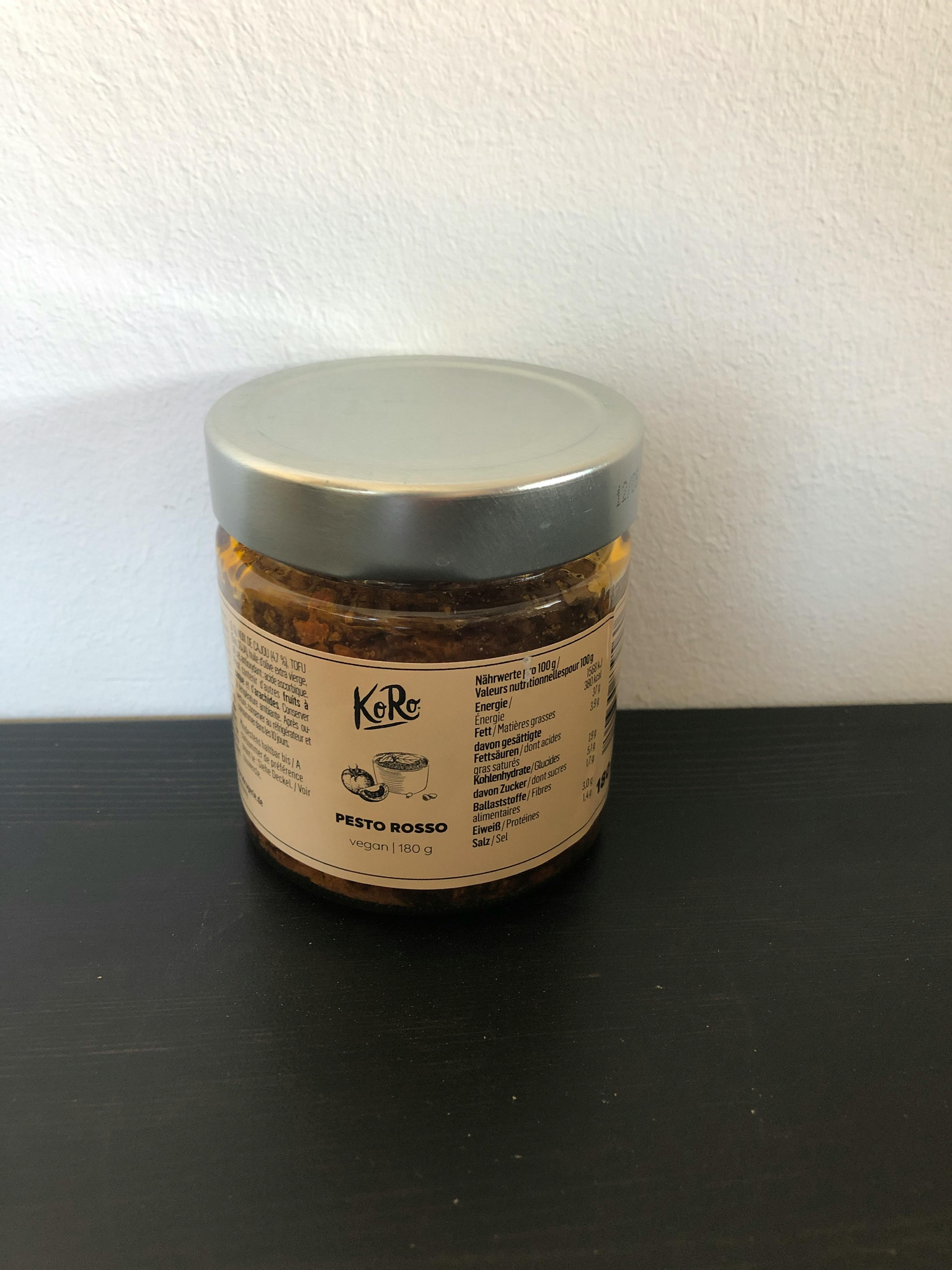 un barattolo di pesto rosso è seduto su un tavolo nero