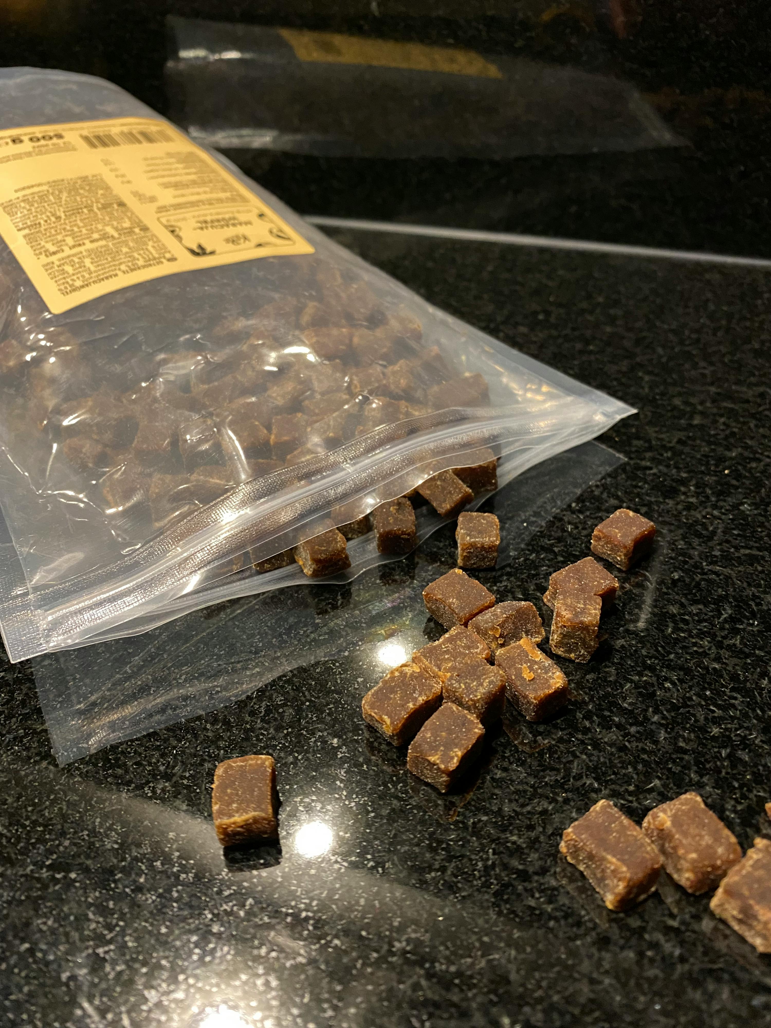 un sac en plastique rempli de morceaux de chocolat sur une table