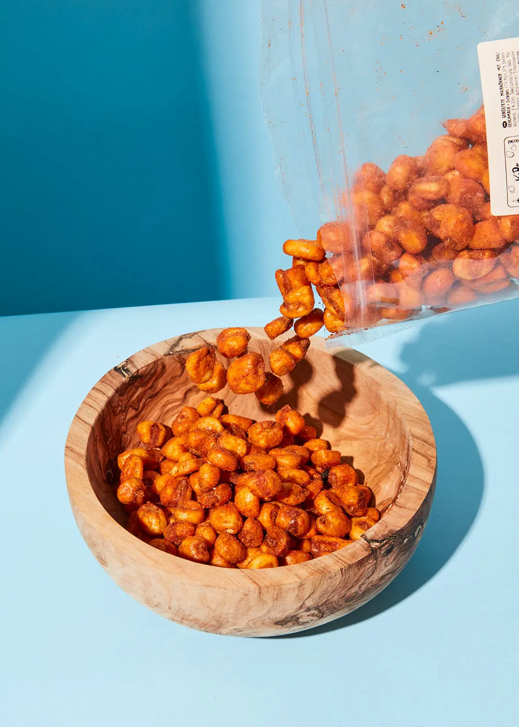 un bol en bois rempli d' arachides et d' un sac en plastique