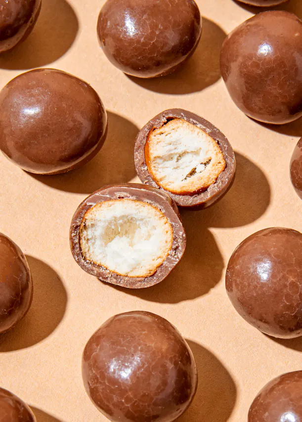 un groupe de bonbons au chocolat sont disposés sur une surface beige