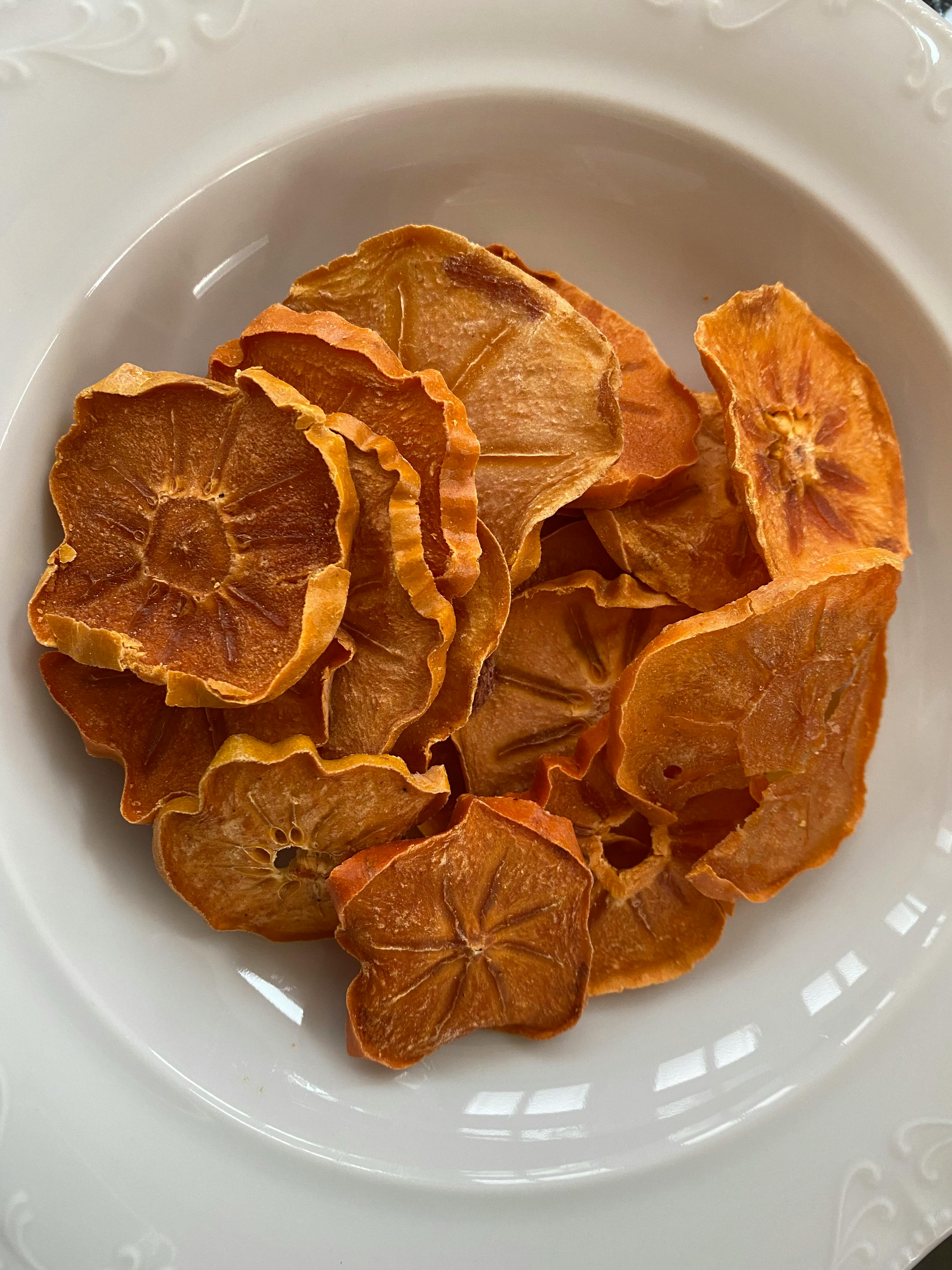 ein weißer Teller mit einem Haufen getrockneter Früchte