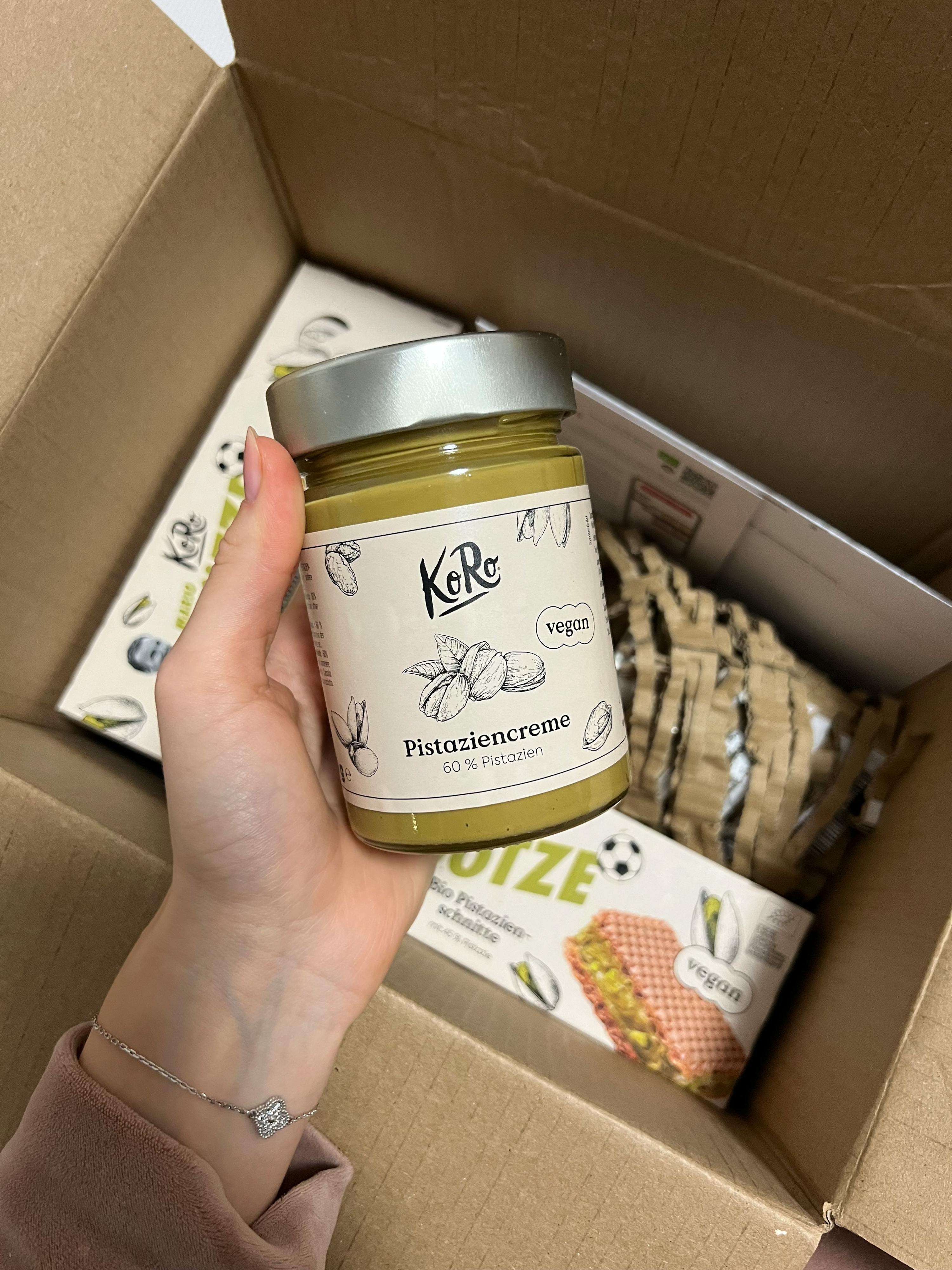 a person is holding a jar of pistaziencreme