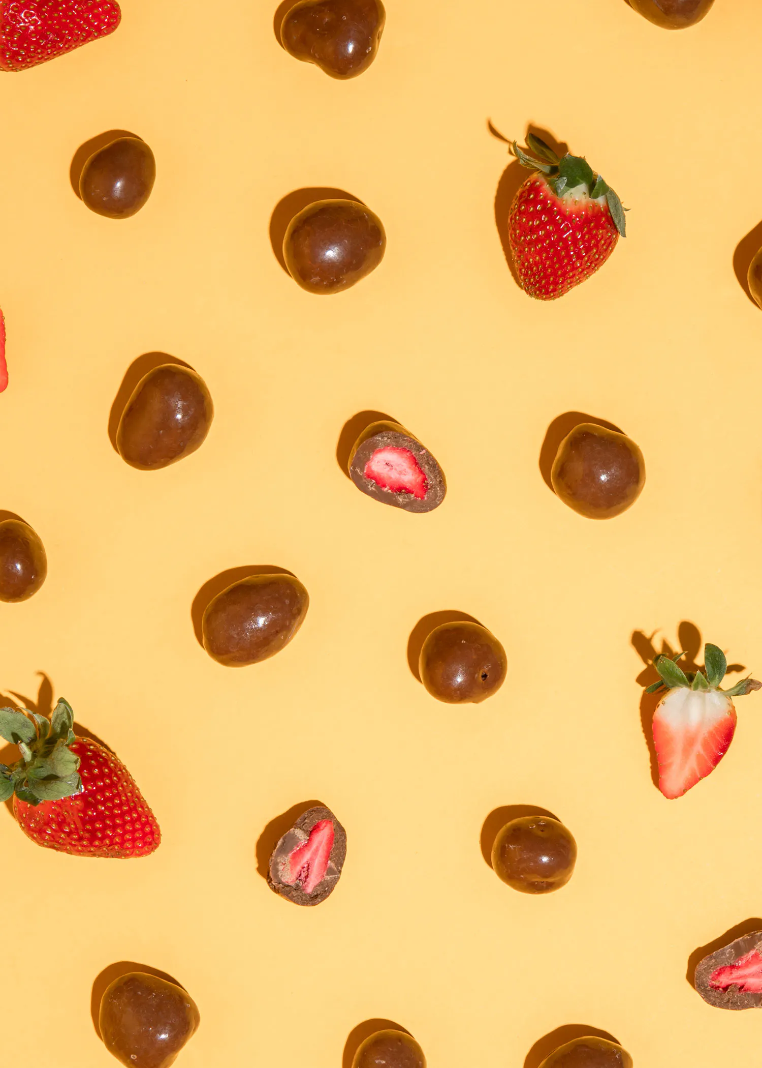 des fraises enrobées de chocolat sur fond jaune