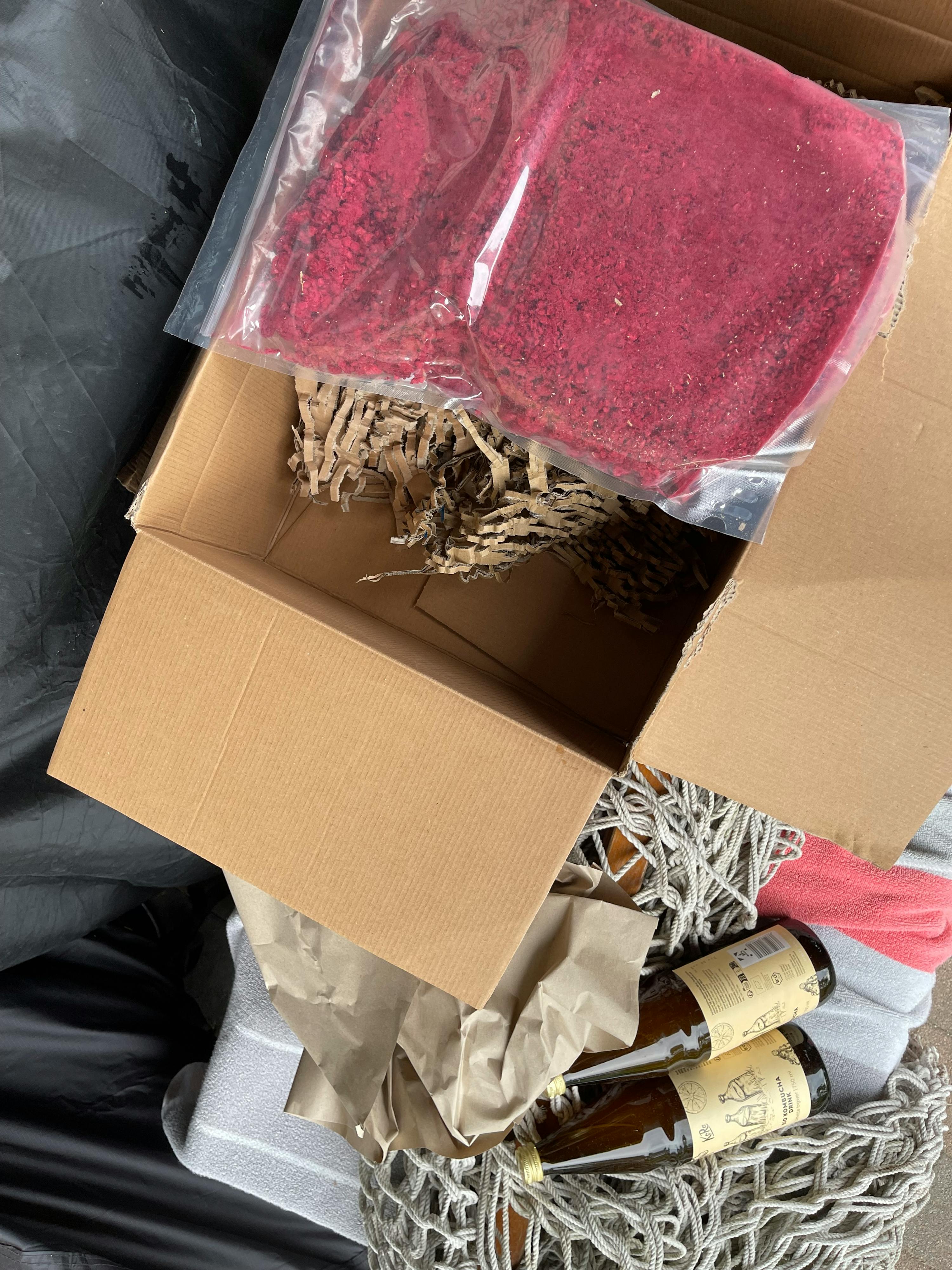 una scatola di cartone piena di cibo e bottiglie di vino