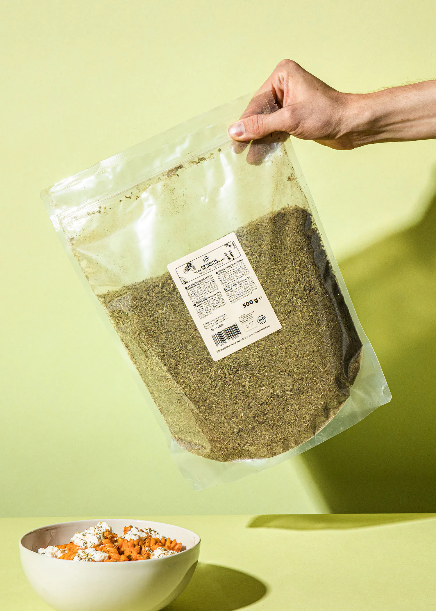 une personne tient un sac de graines à côté d' un bol de céréales