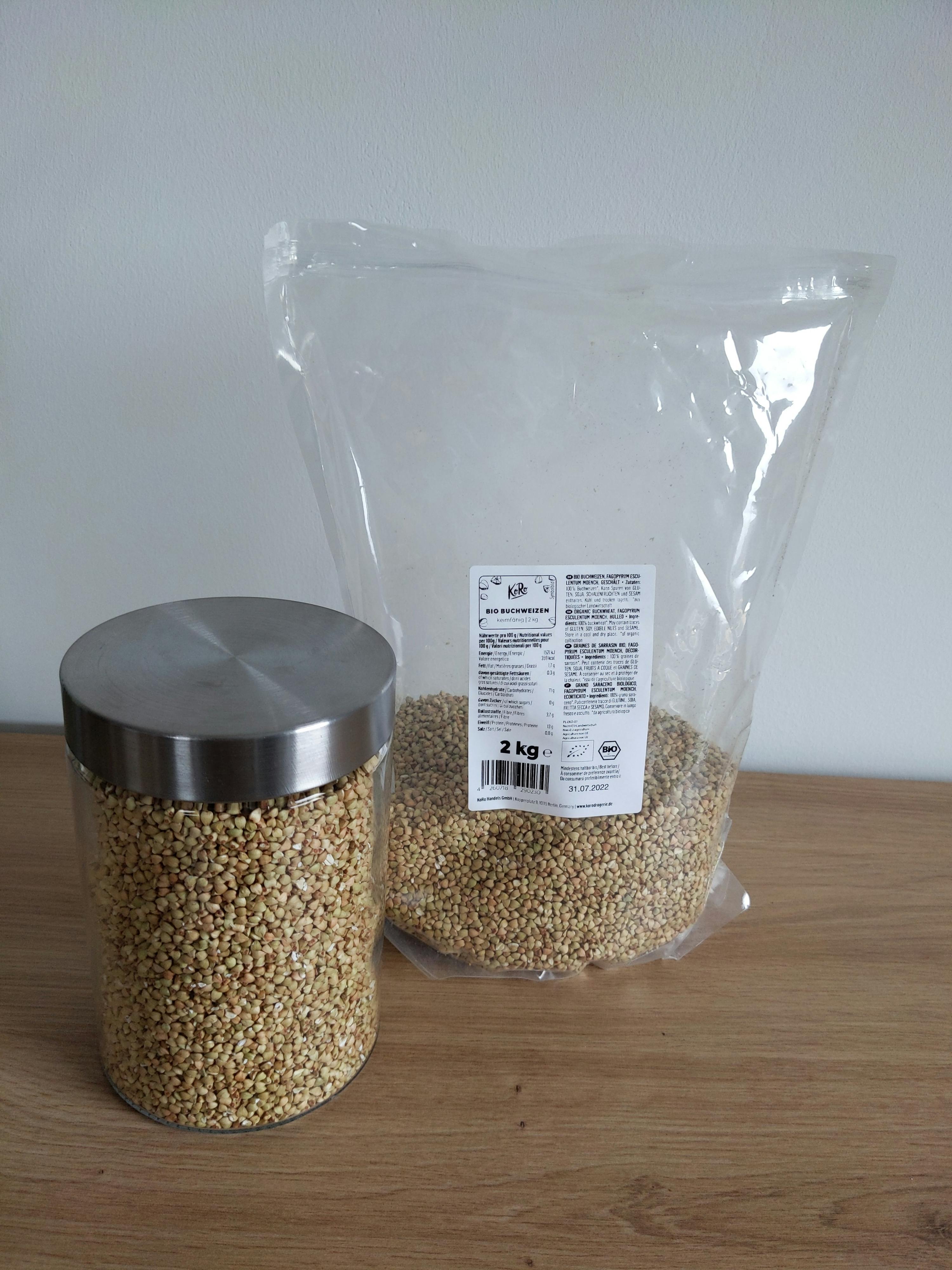 un sacchetto di grano e un barattolo di grano sono seduti su un tavolo di legno