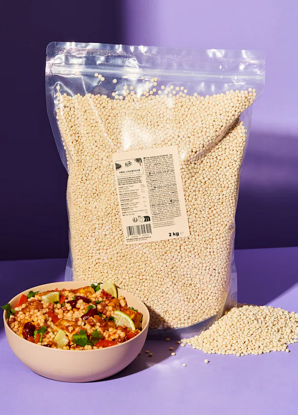 a bag of pearl couscous sits next to a bowl of food