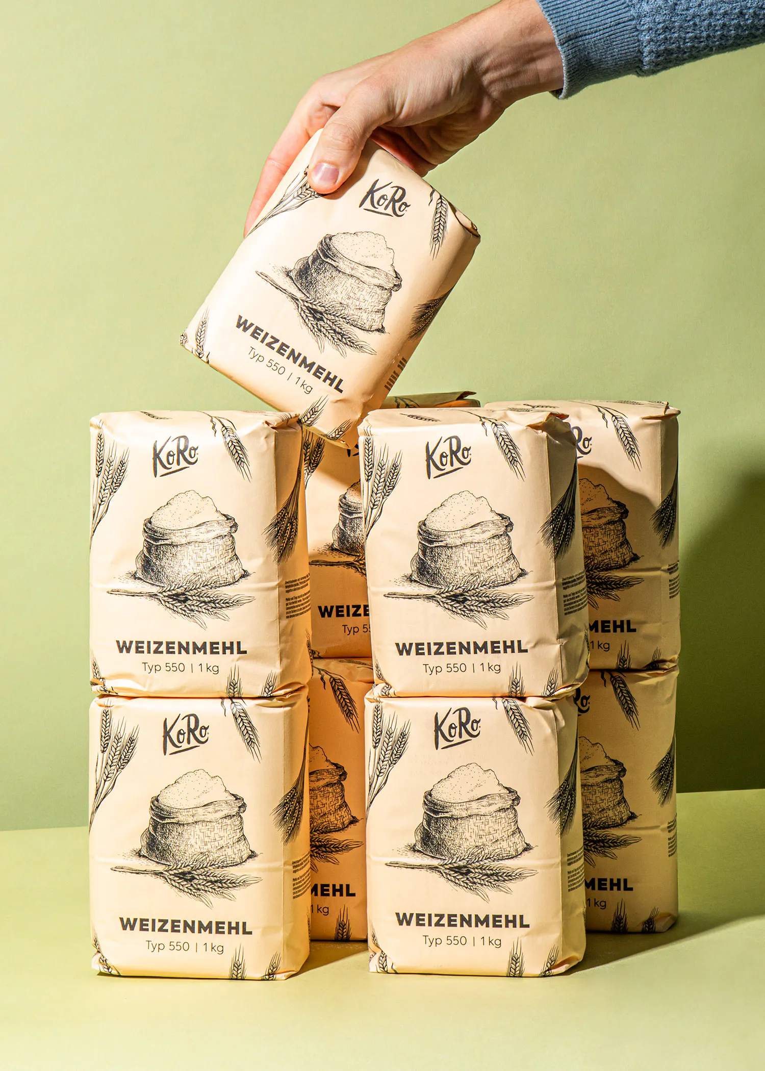 Eine Person hält eine Tüte Weizenmehl in der Hand