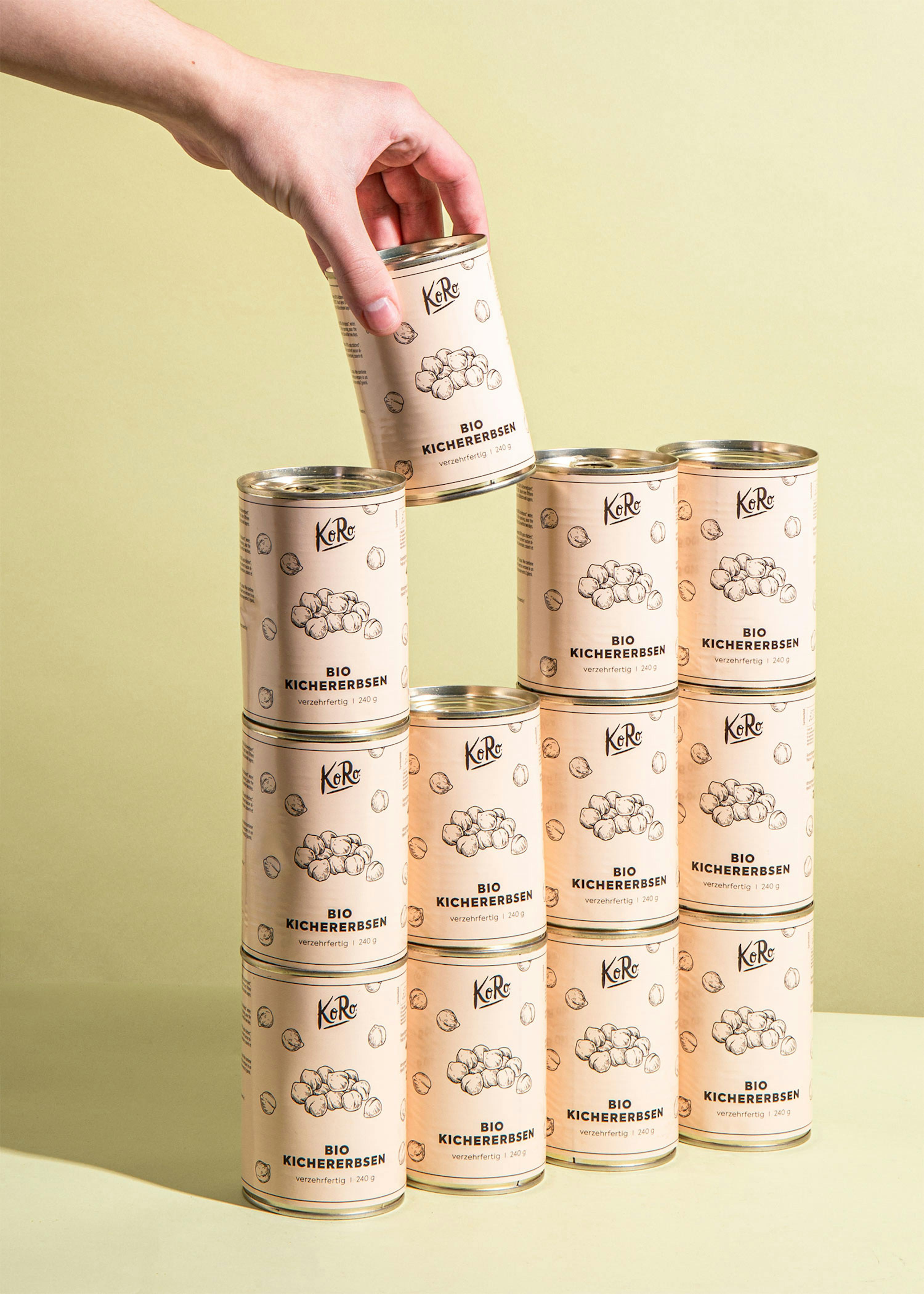 una persona tiene in mano una lattina di kichererbsen bio