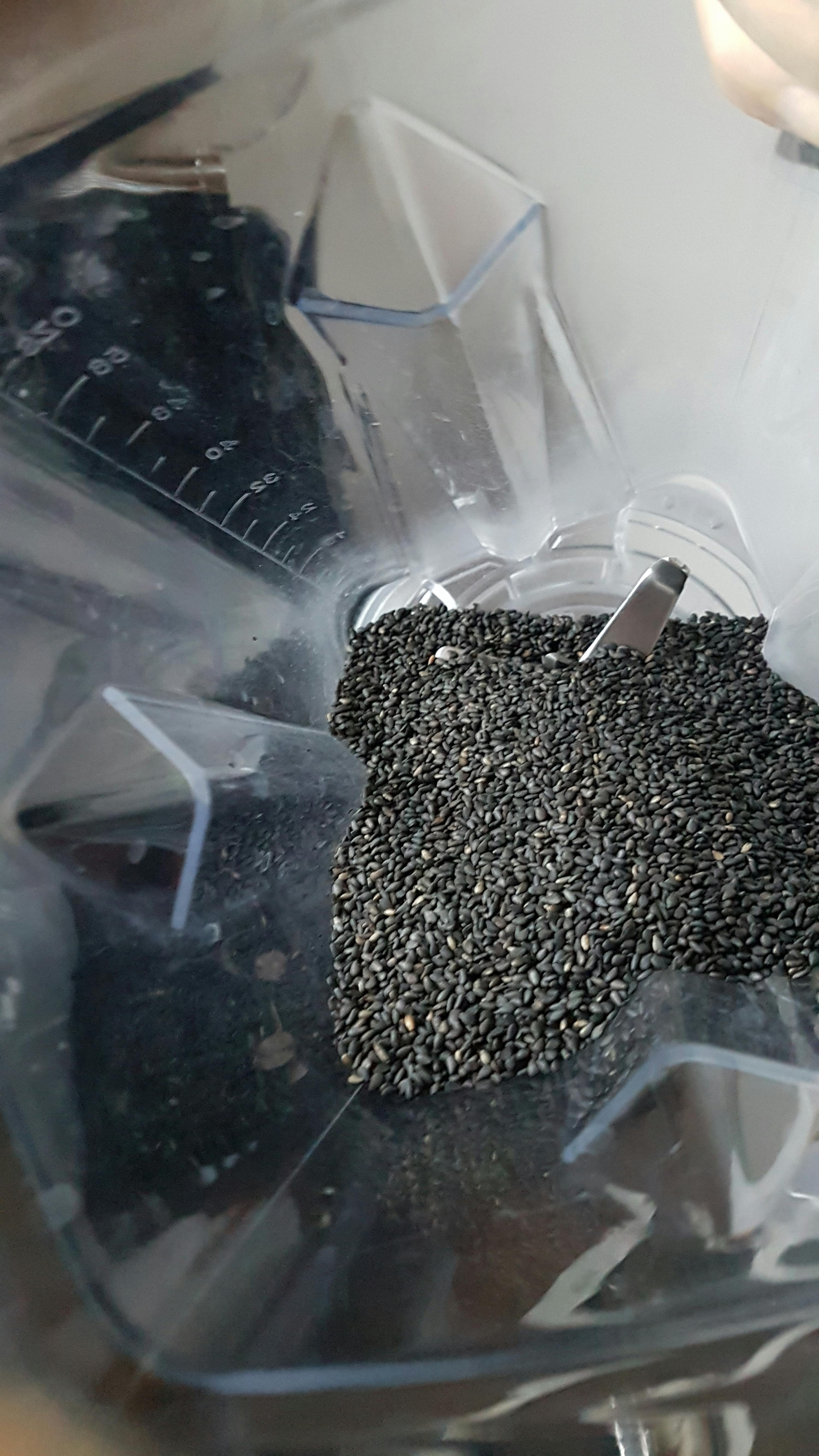 ein Mixer füllt sich mit schwarzen Sesamsamen