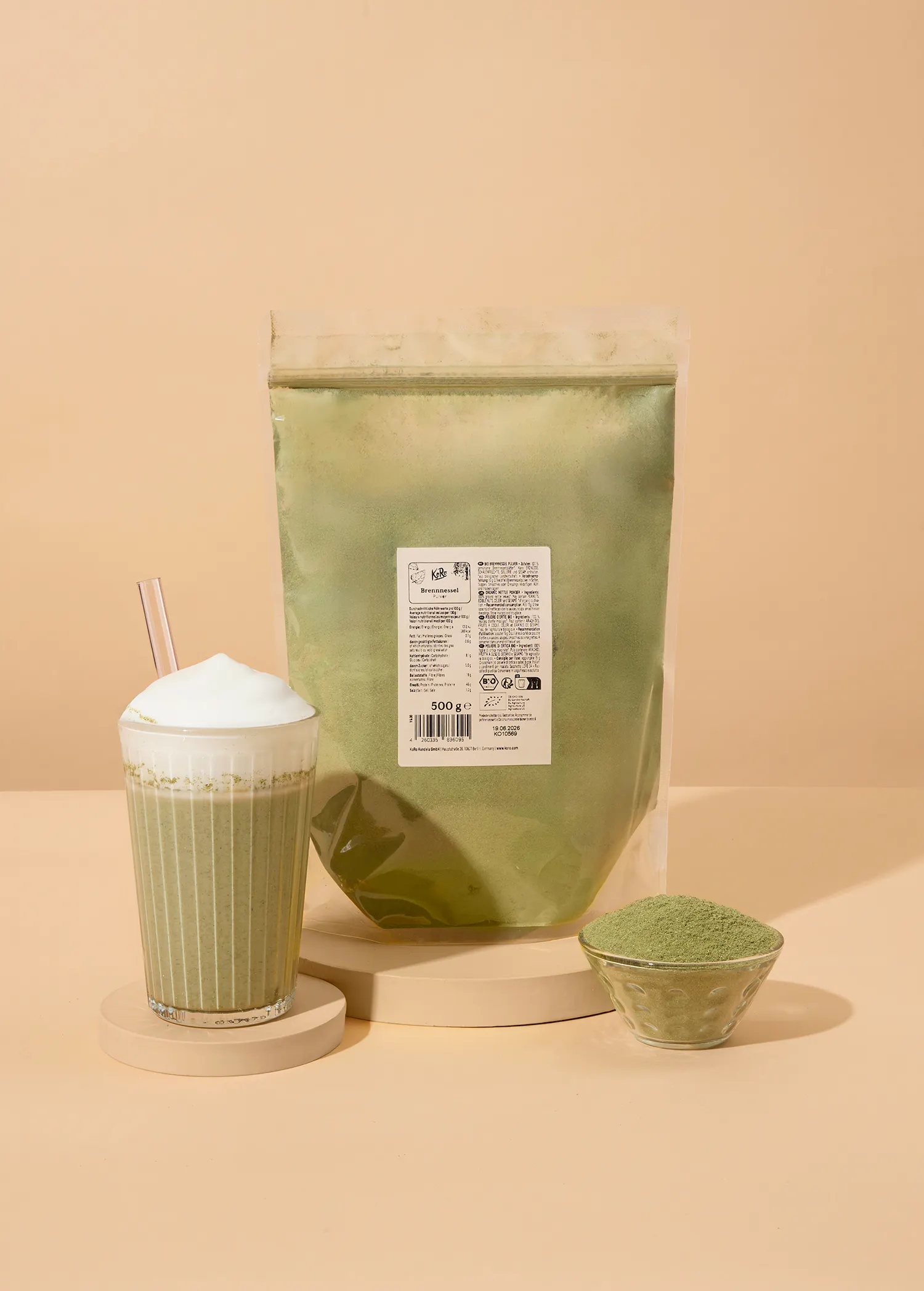 a bag of green powder next to a cup of green liquid