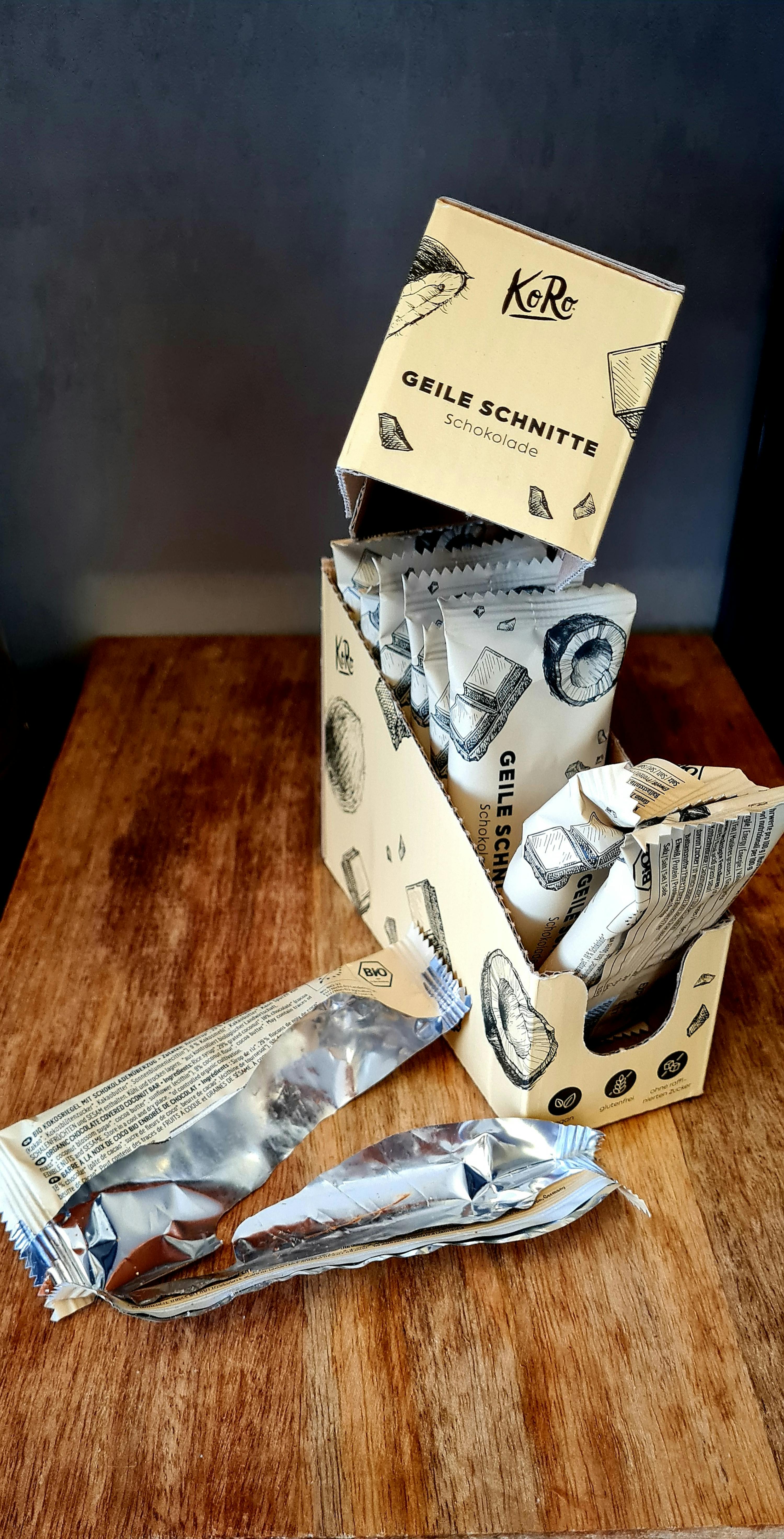 eine Schachtel geile schnitte-Schokolade liegt auf einem Holztisch