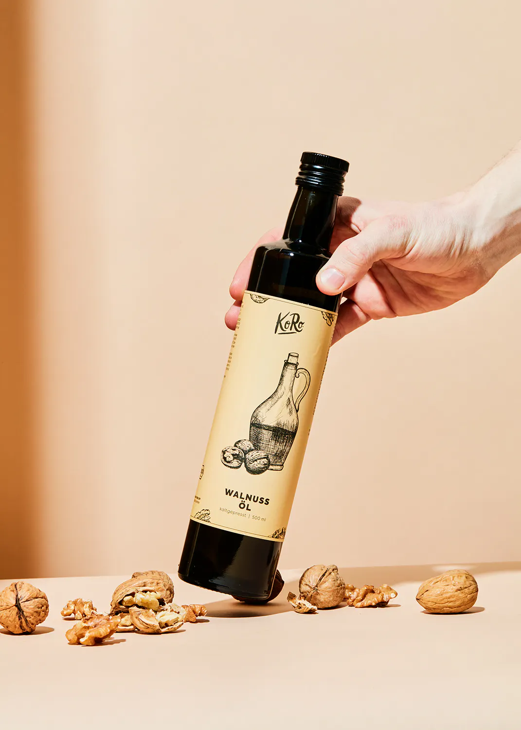 a hand is holding a bottle of walnut oil