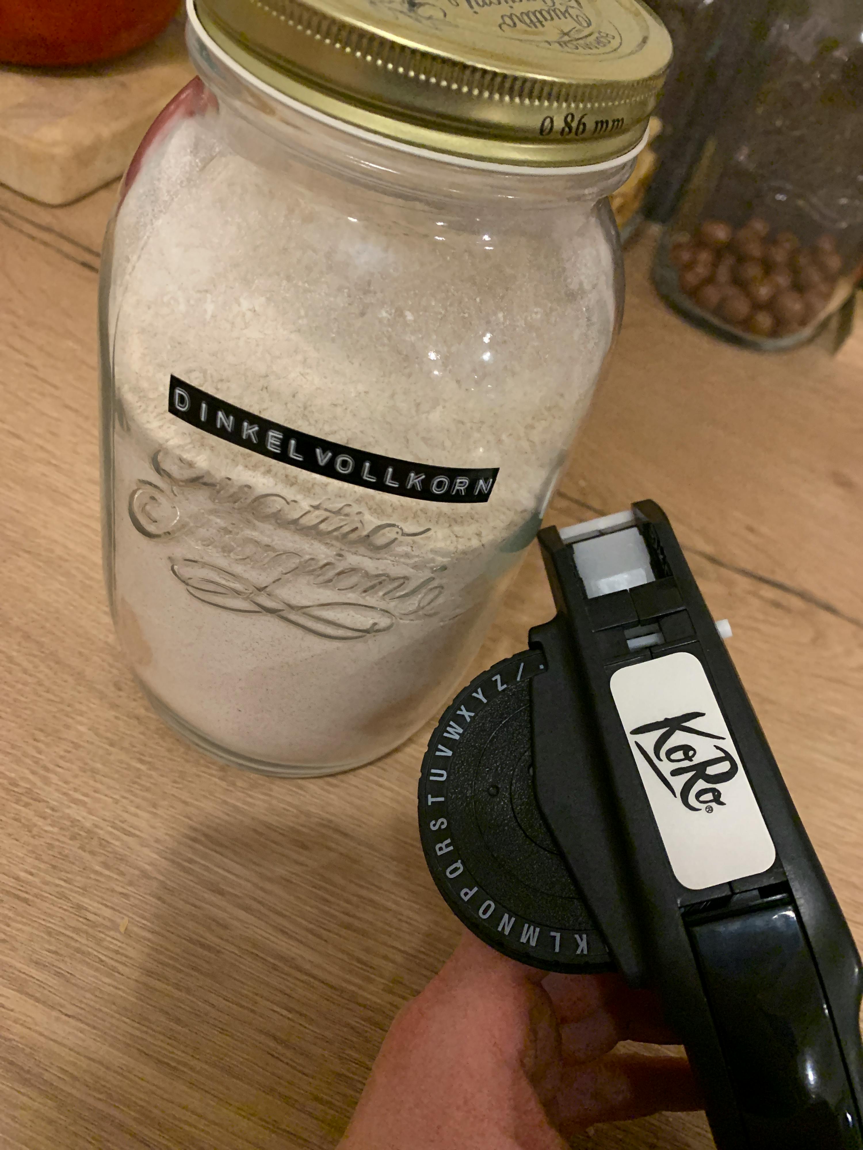 a person is labeling a jar with the word dinkelvollkorn