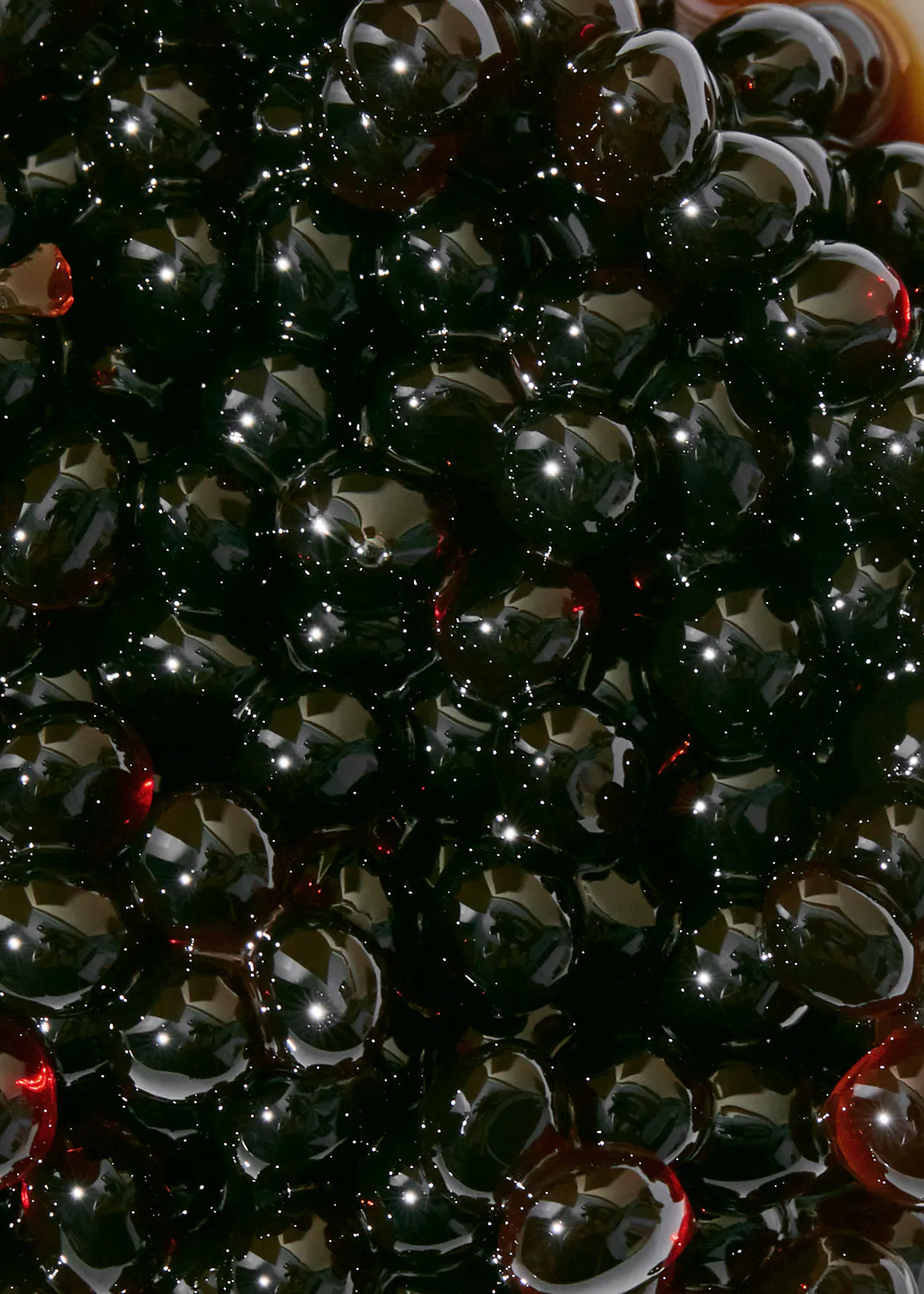a close up of a pile of black beads with a red center