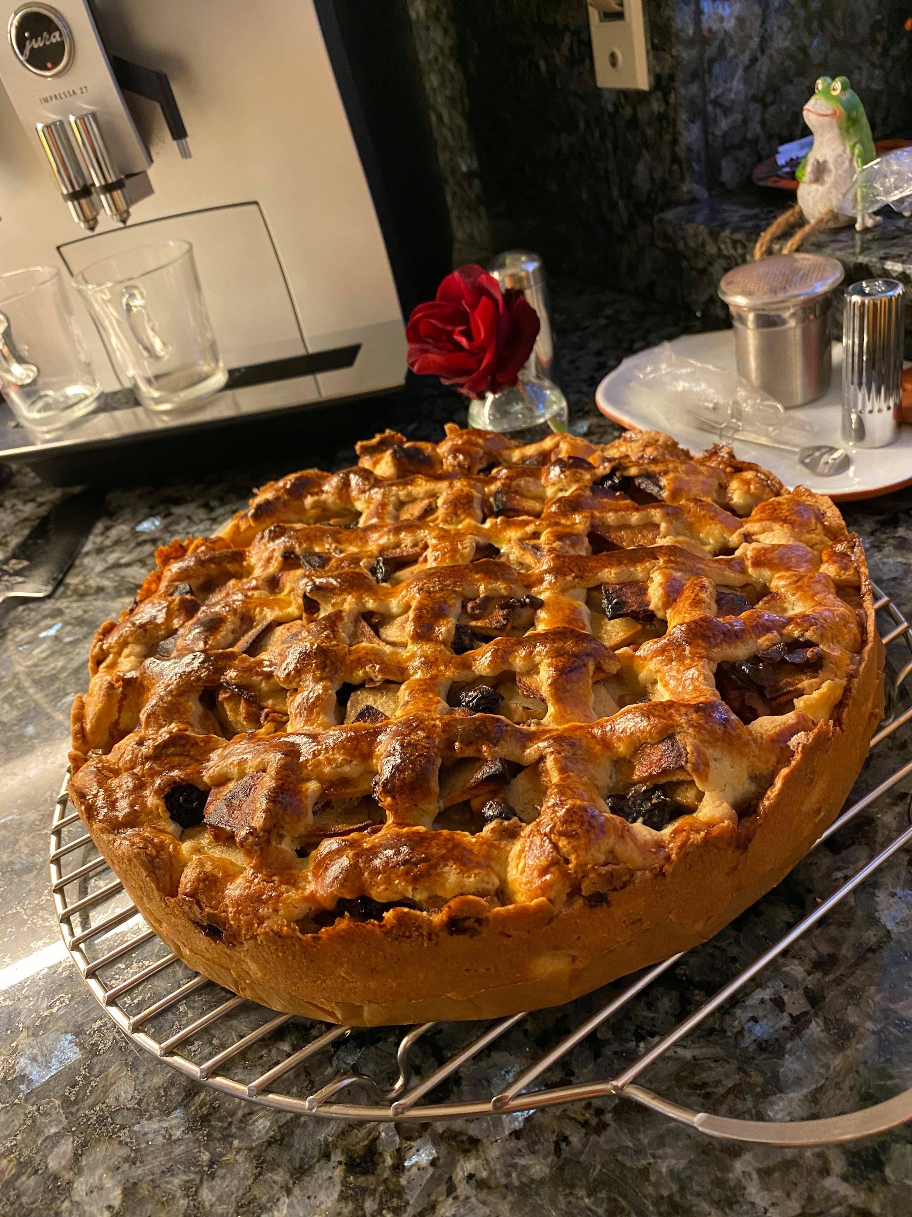 ein Apfelkuchen sitzt auf einem Kühlregal neben einer kaffeemaschine