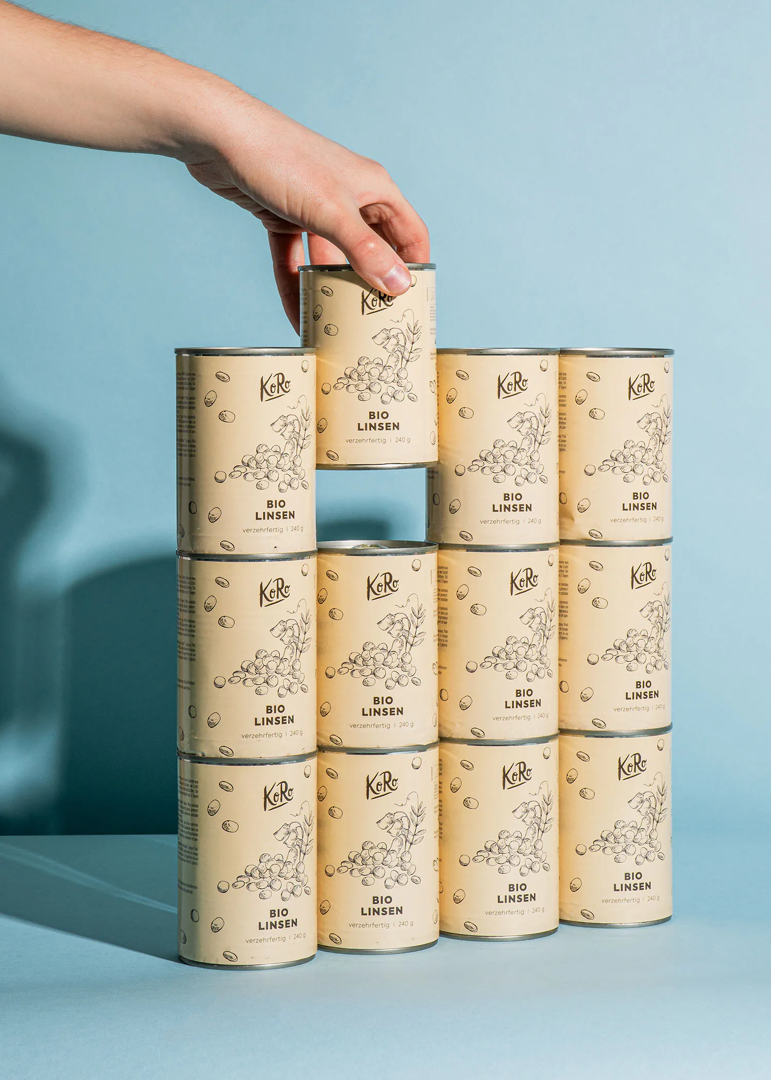 a hand reaches for a can of bio linsen