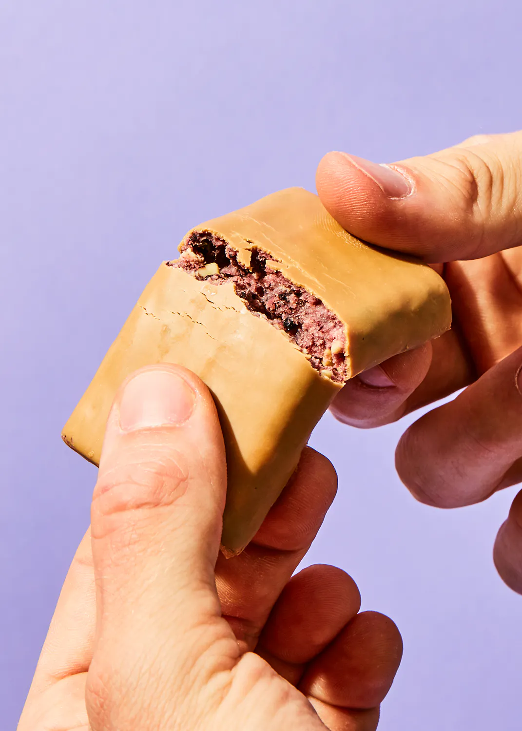 une personne tient une barre de chocolat avec une bouchée sortie