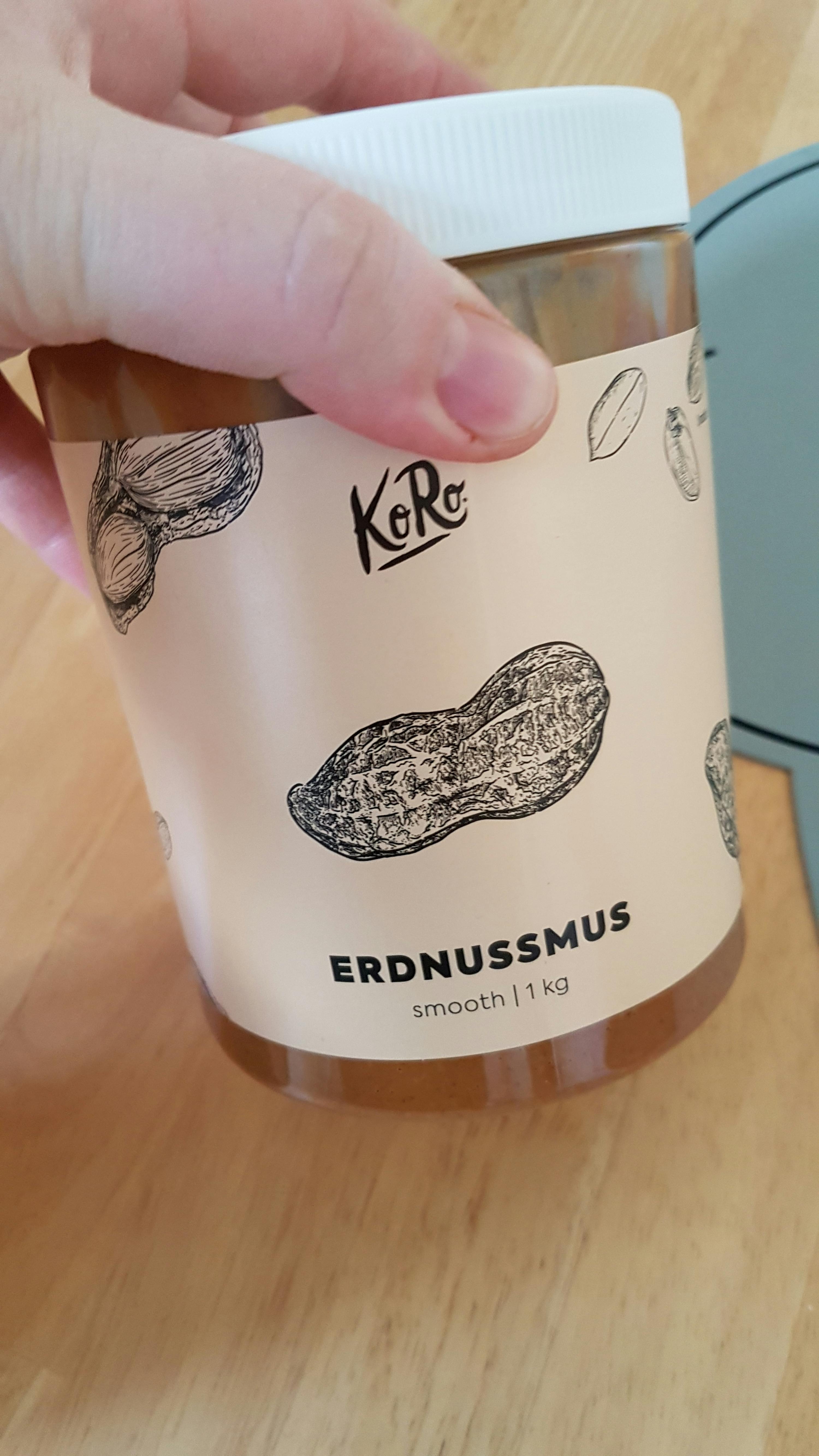 a person holding a jar of erdnussmus peanut butter