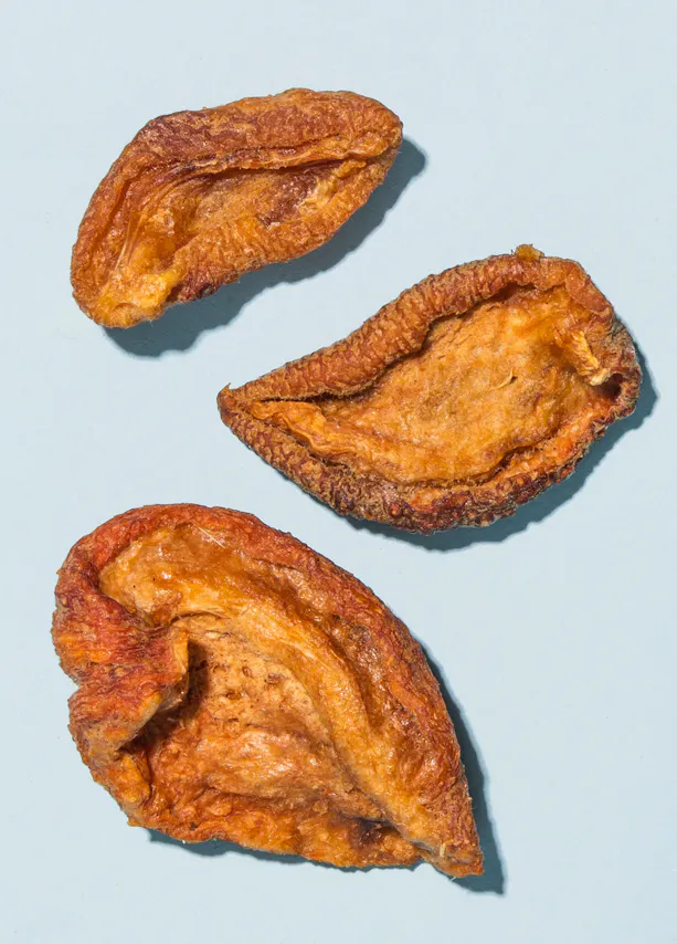 trois morceaux de fruits séchés sur fond bleu