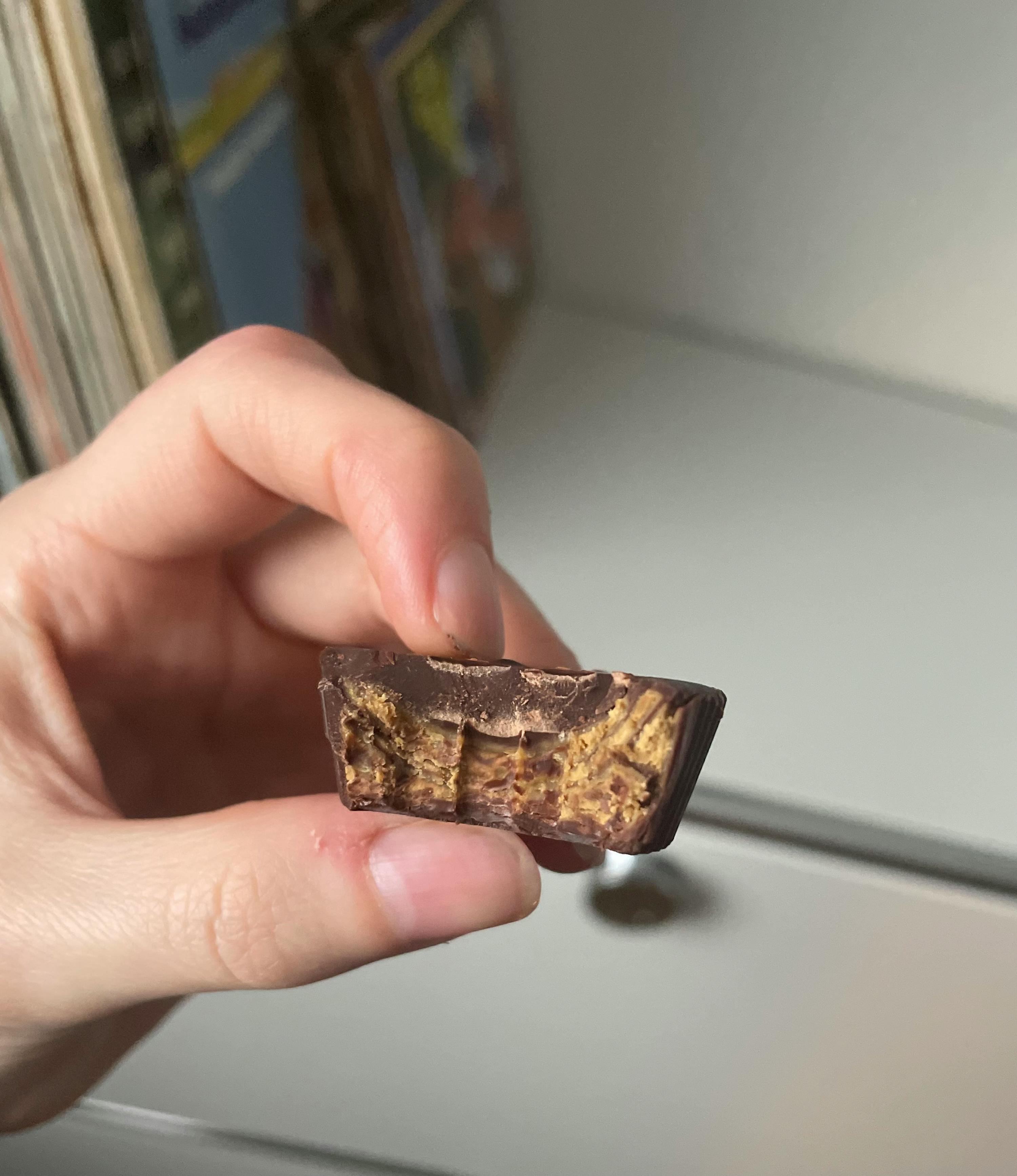 une personne tient un gâteau au beurre d' arachide dans sa main