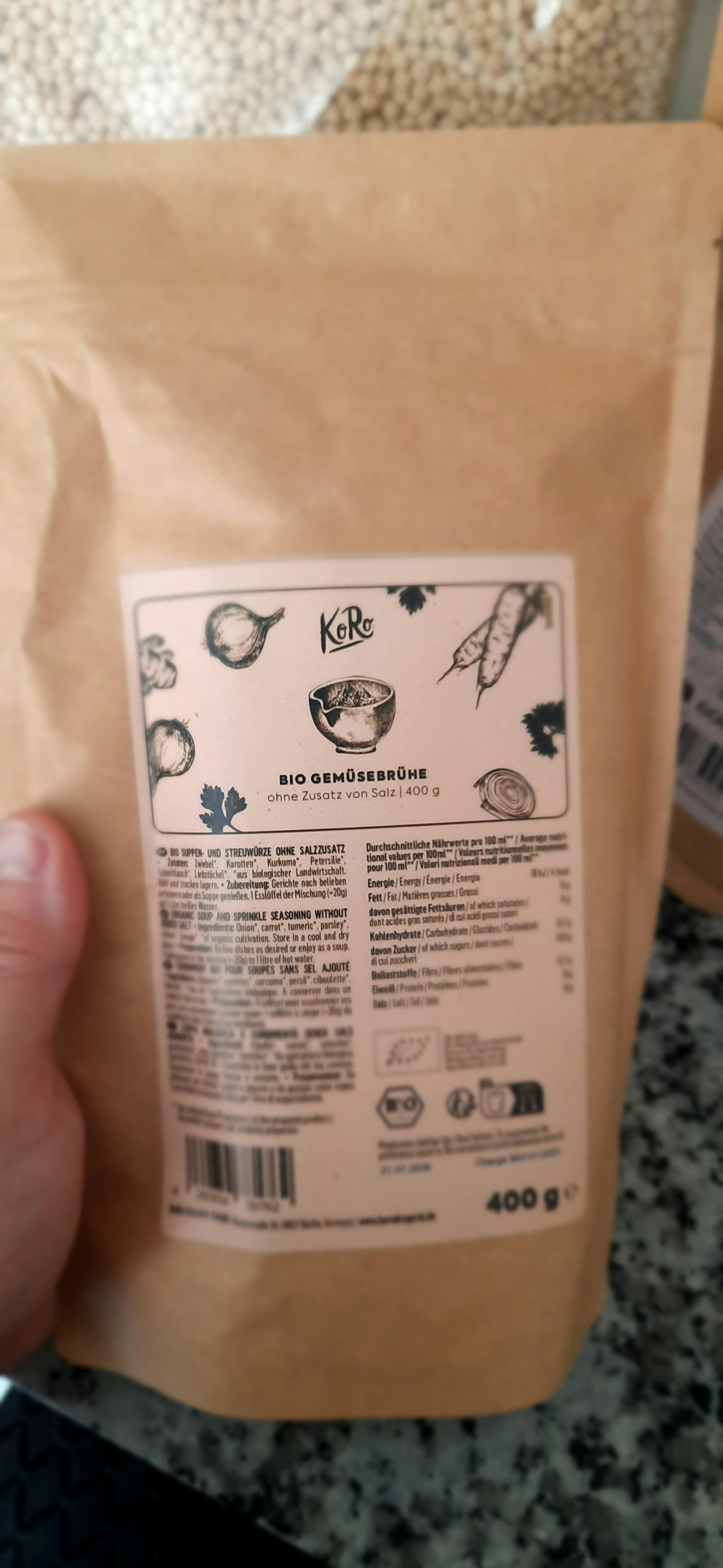 Eine Person hält eine verpackte Bio-Gemüsebrühe in der Hand