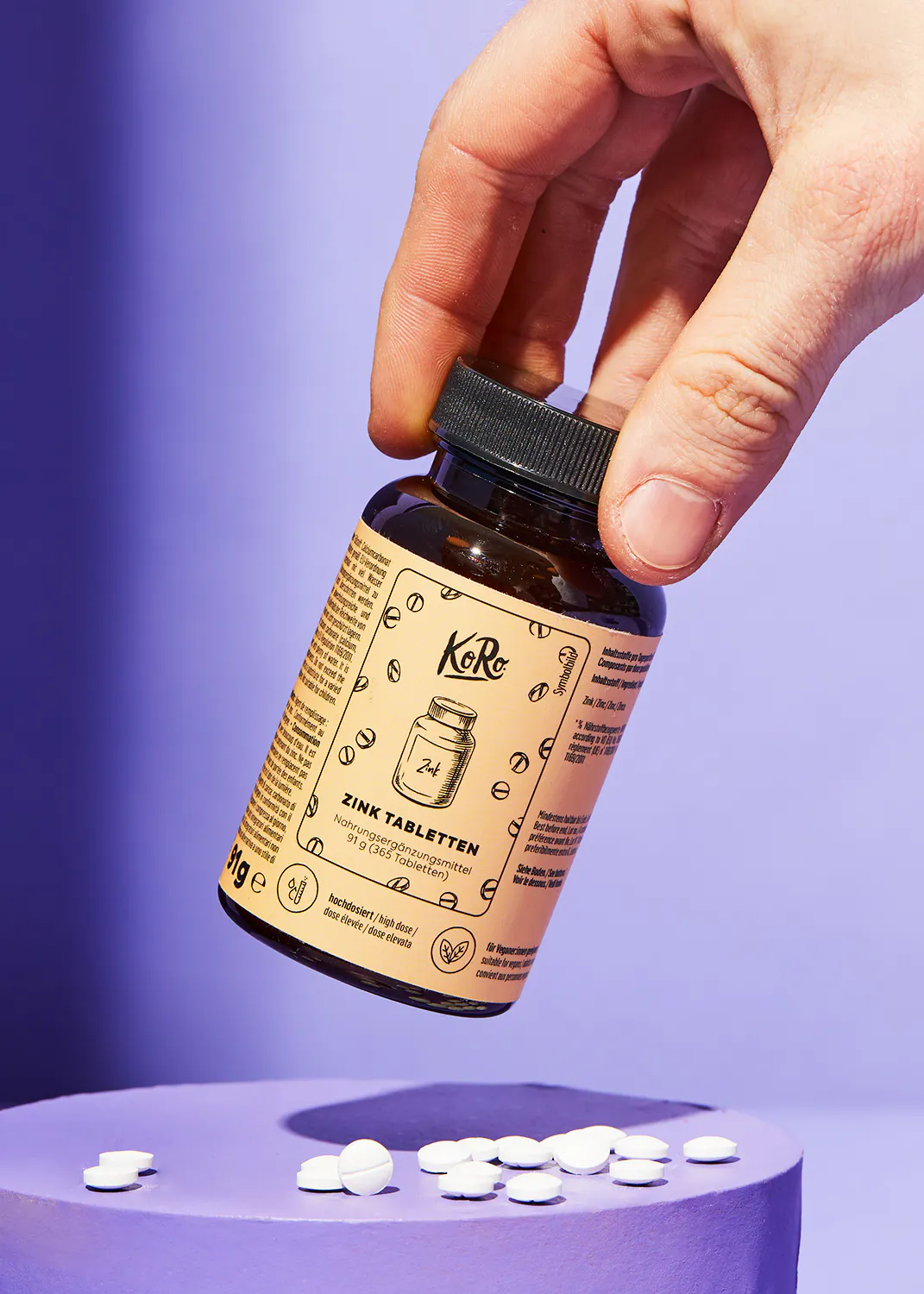 a person is holding a bottle of zinc tabletten