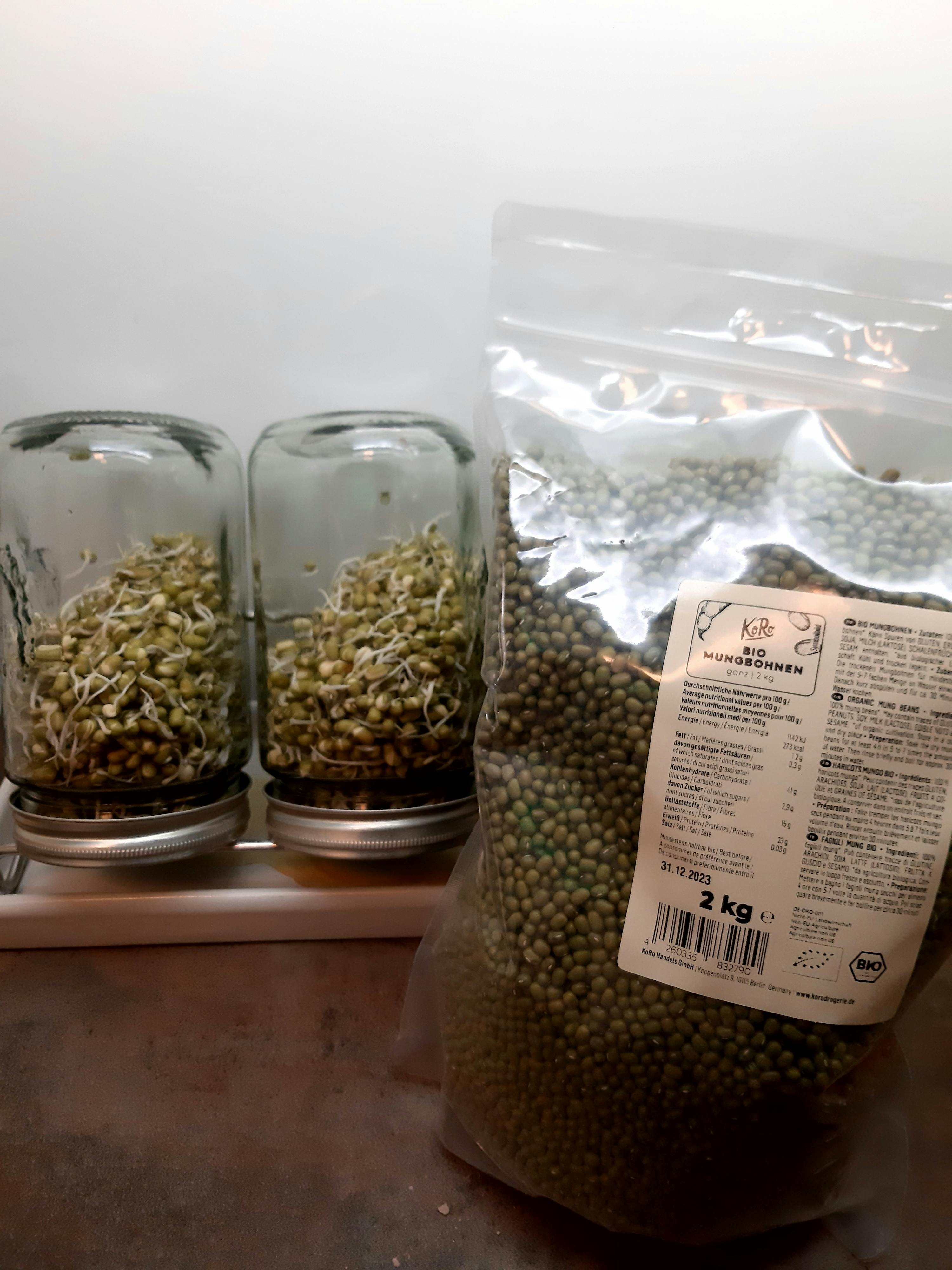 a bag of green beans sits next to two jars of sprouts