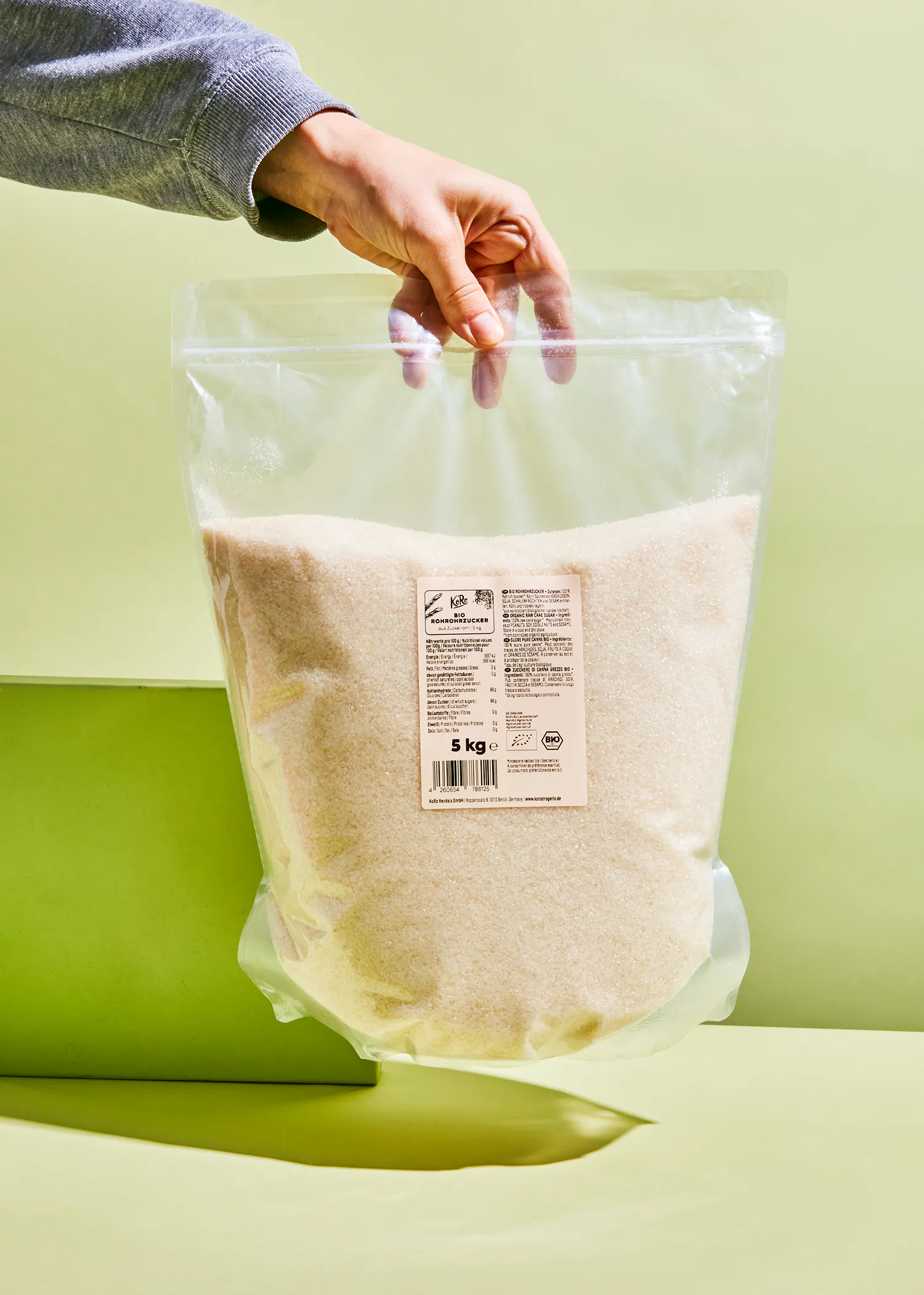 eine Person hält einen Plastikbeutel mit einem Gewicht von 5 kg