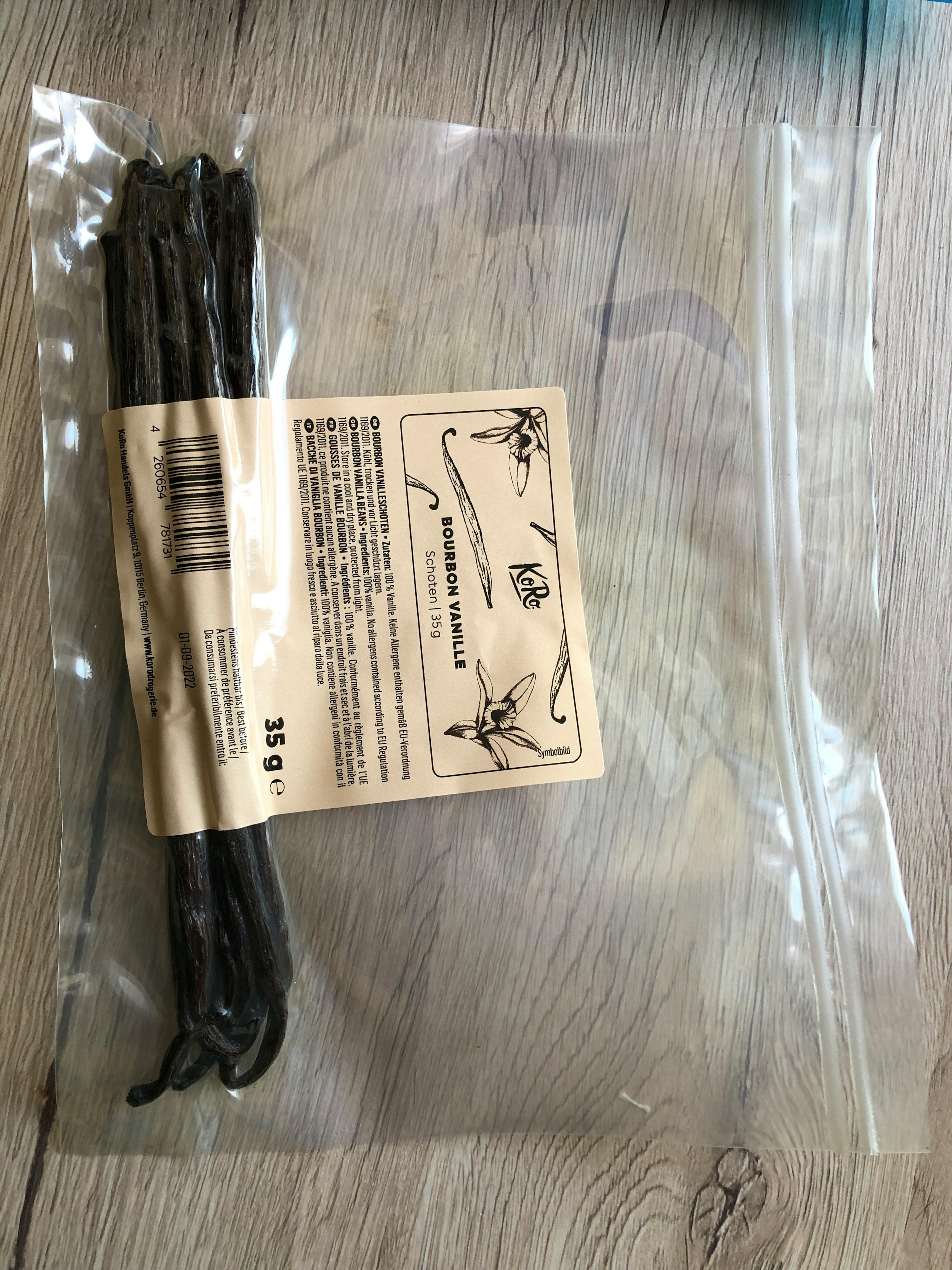 un sacchetto di bastoncini di vaniglia è seduto su un tavolo di legno