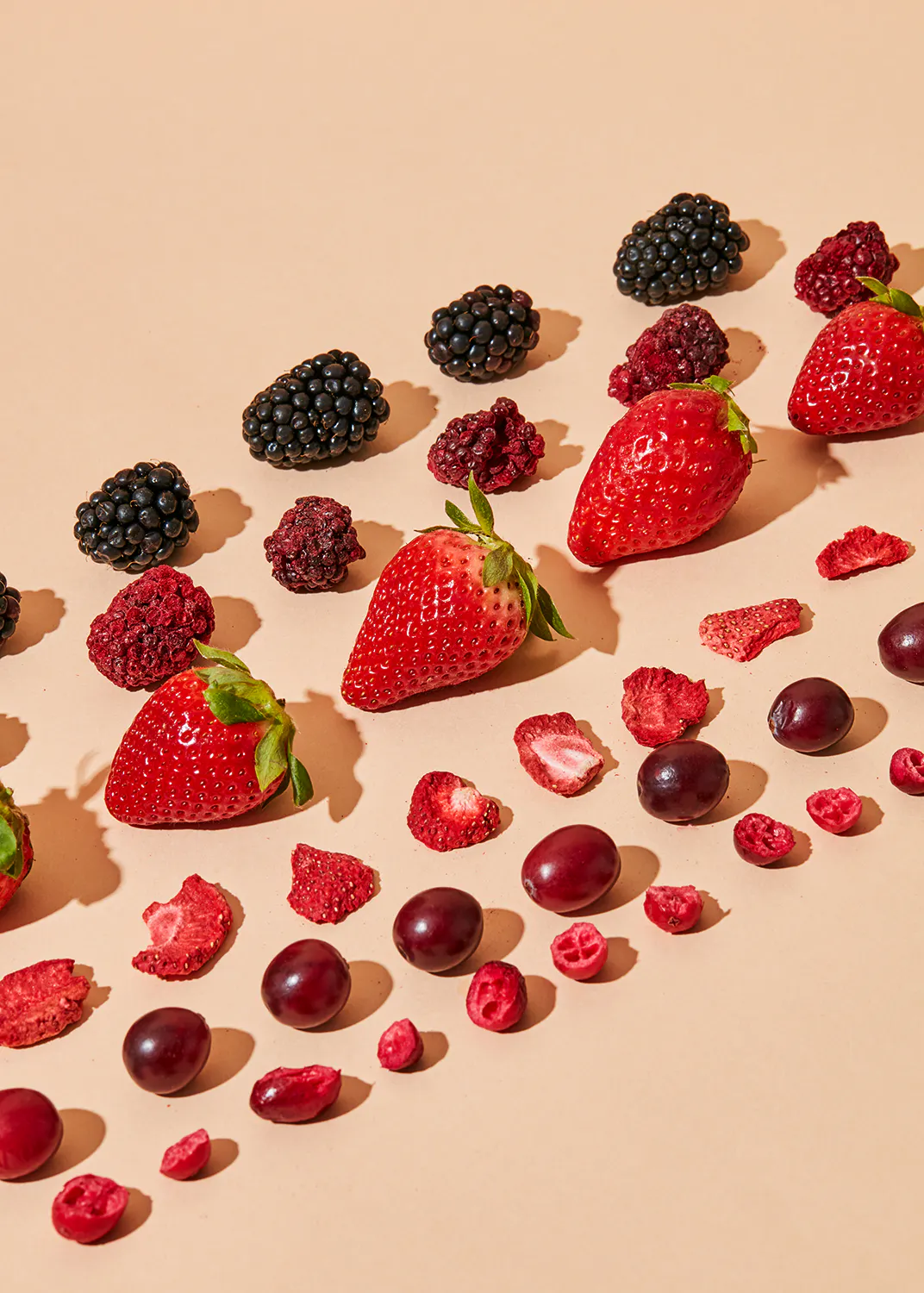 strawberries blackberries grapes and cranberries arranged in a row
