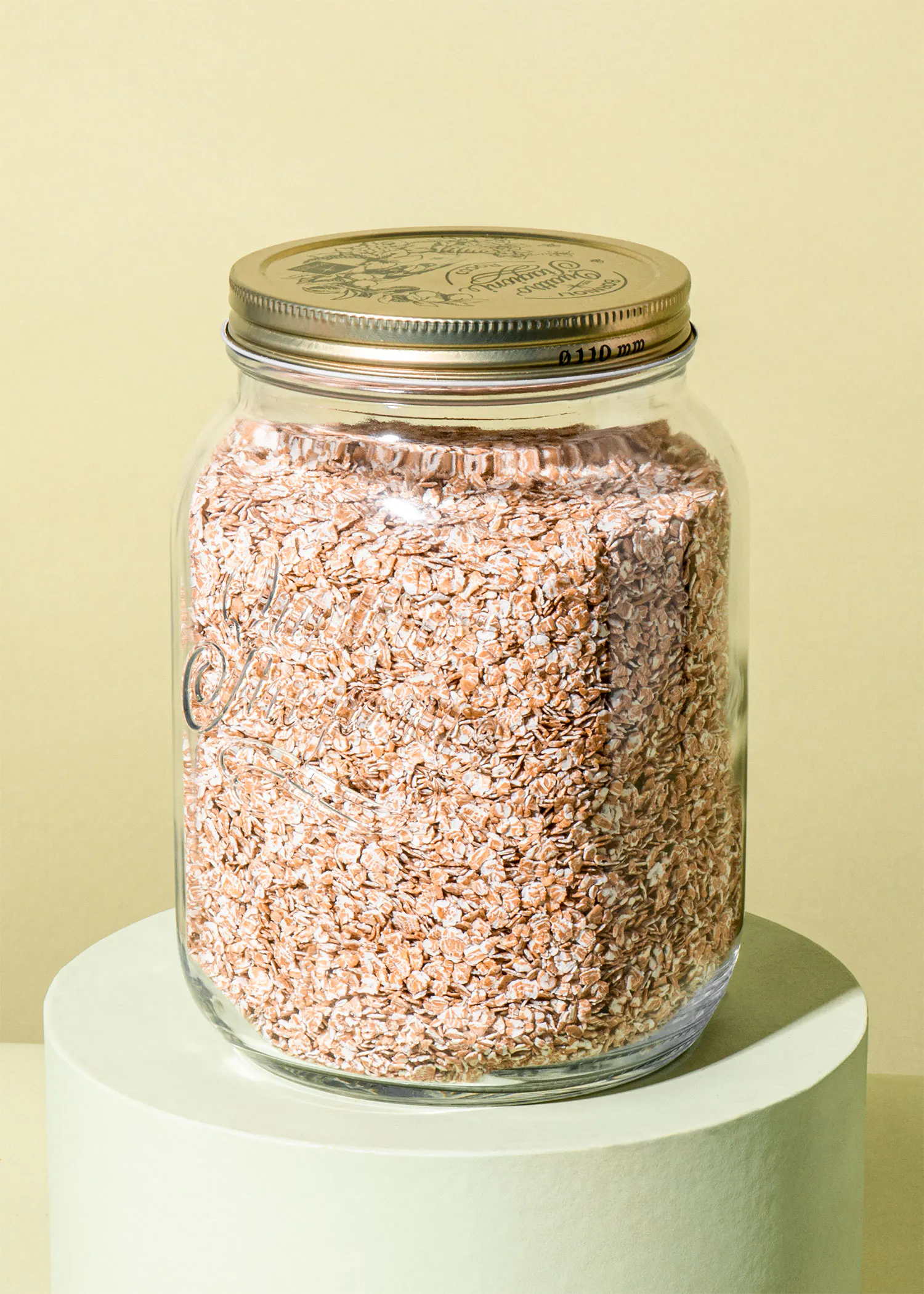 un bocal en verre rempli de flocons d' avoine avec un couvercle en métal
