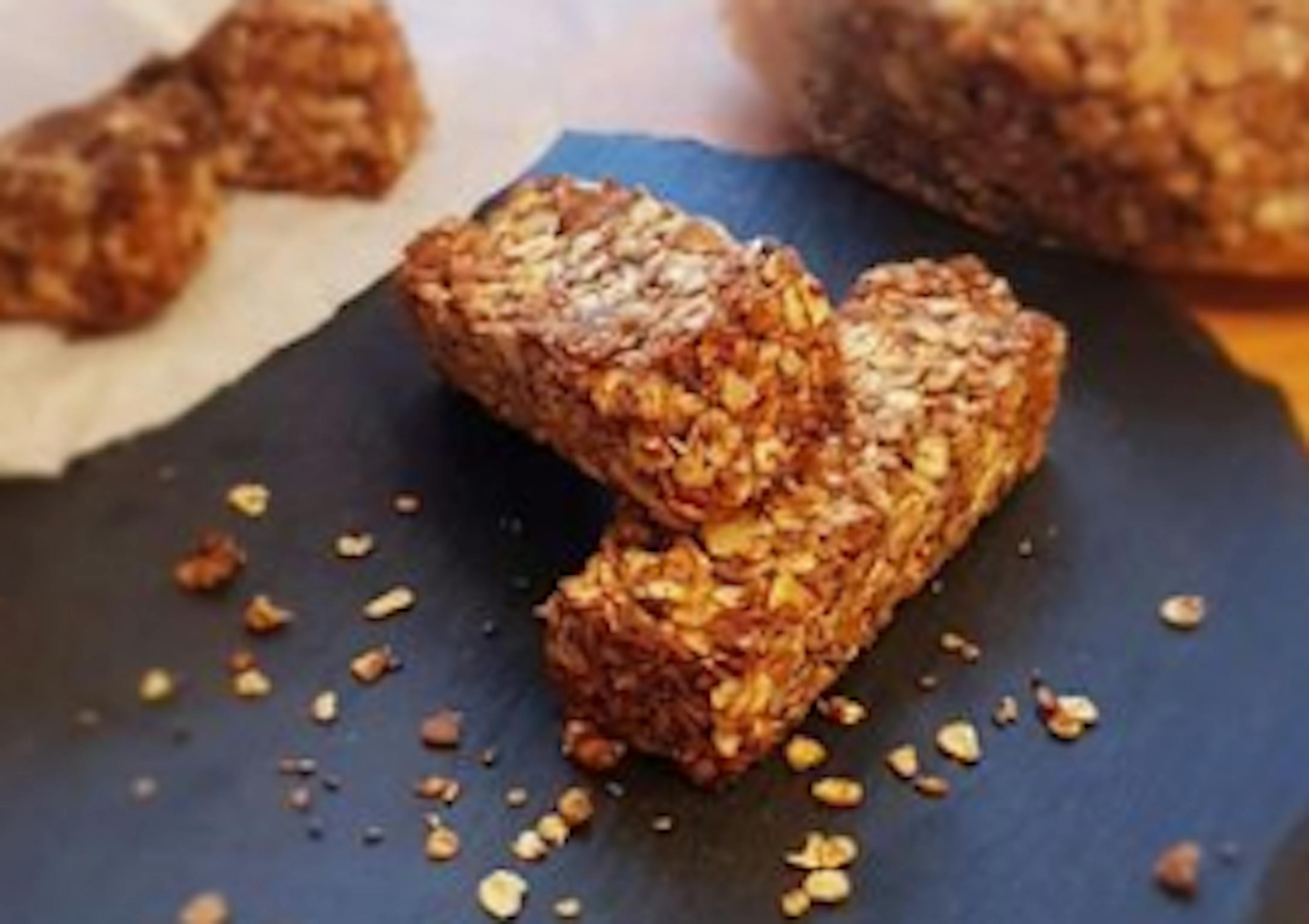 Auf einem schwarzen Teller liegen zwei Müsli-Bars .