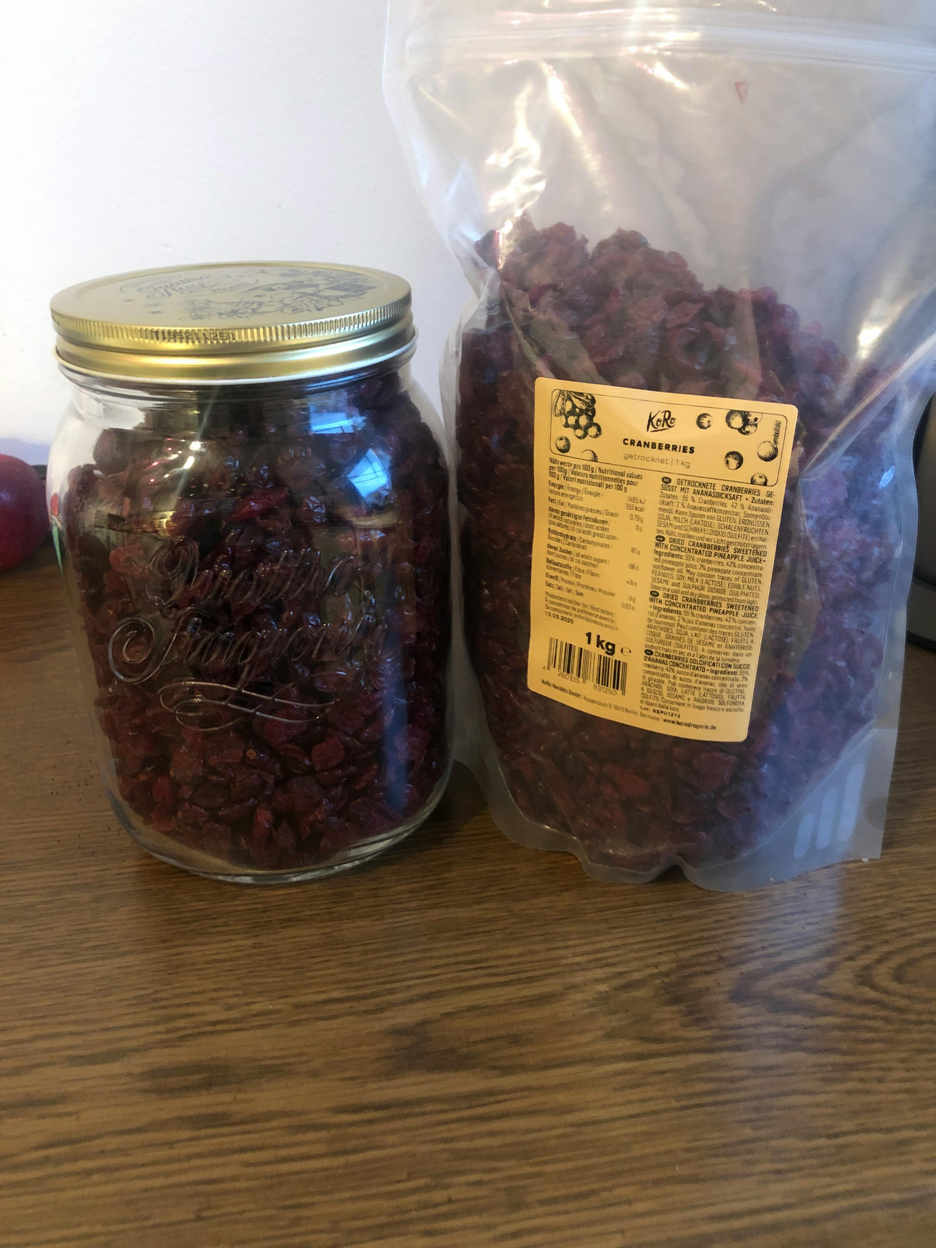 a jar of dried cranberries sits next to a bag of dried cranberries