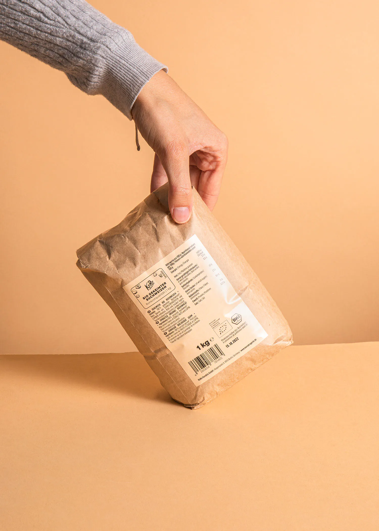 une personne tient un sac de 1 kg de farine de blé