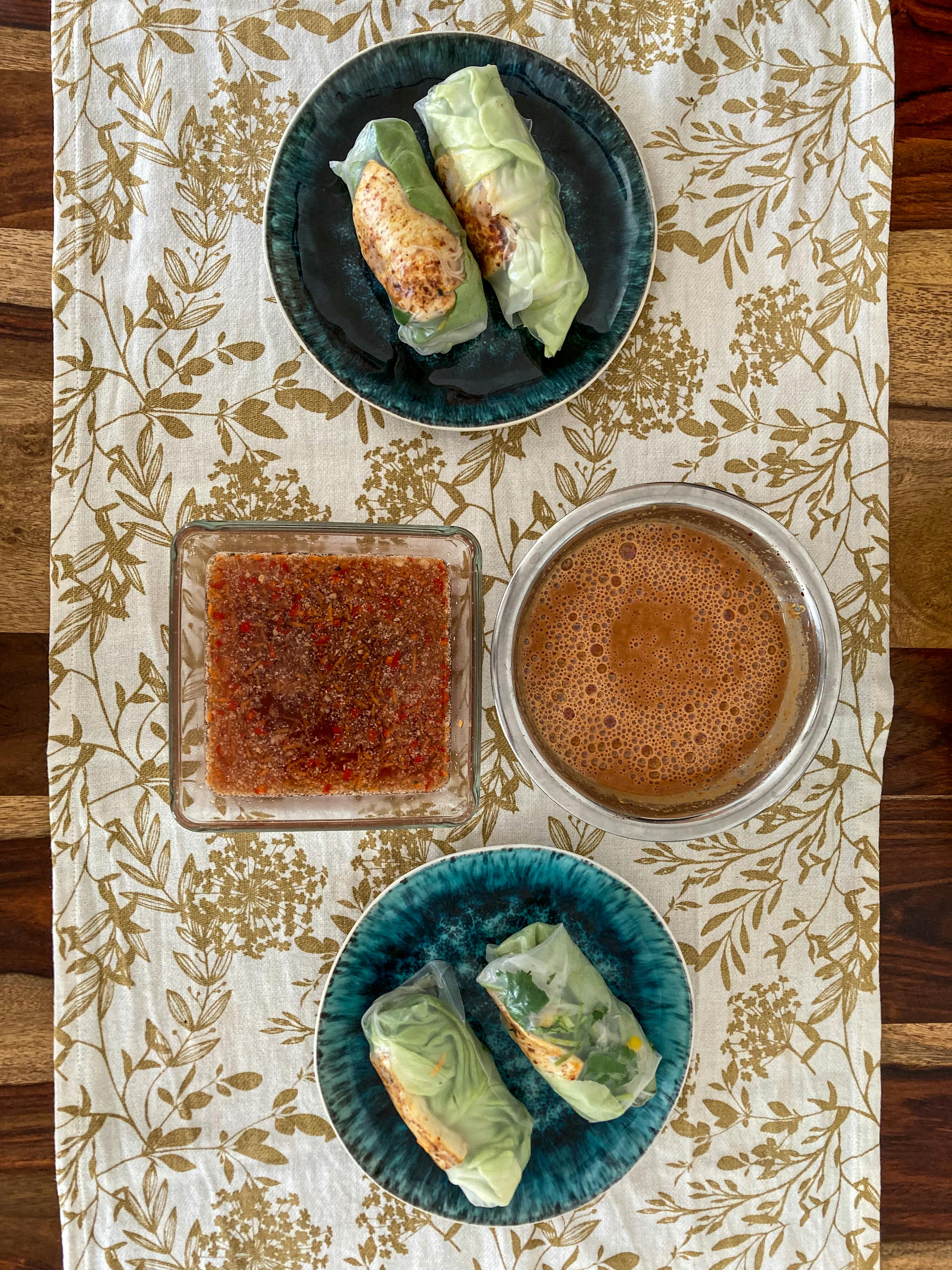 a table with plates of food and sauces on it