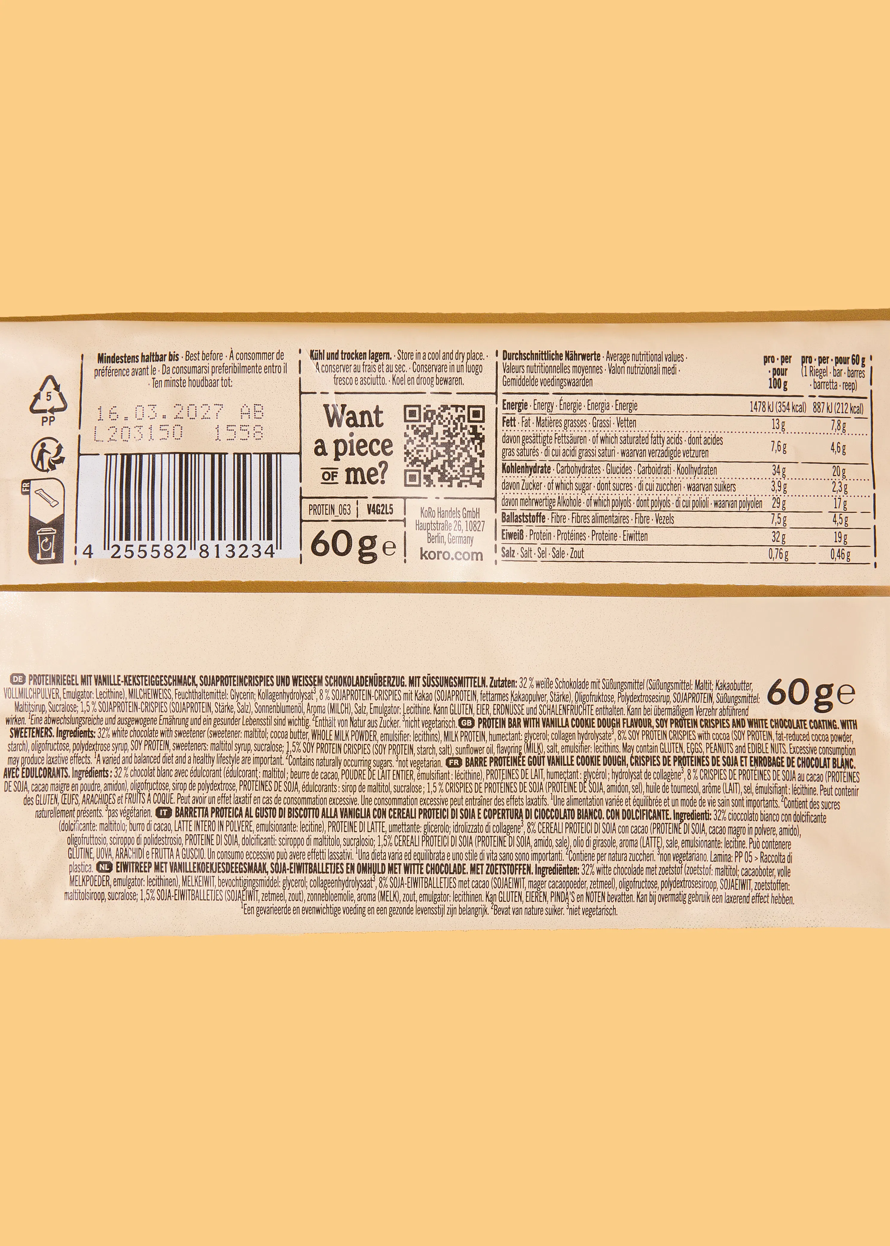 etichetta di una barretta proteica al gusto di biscotto alla vaniglia con cereali di soia e copertura di cioccolato bianco, che mostra la data di scadenza, le informazioni nutrizionali e gli ingredienti in più lingue.