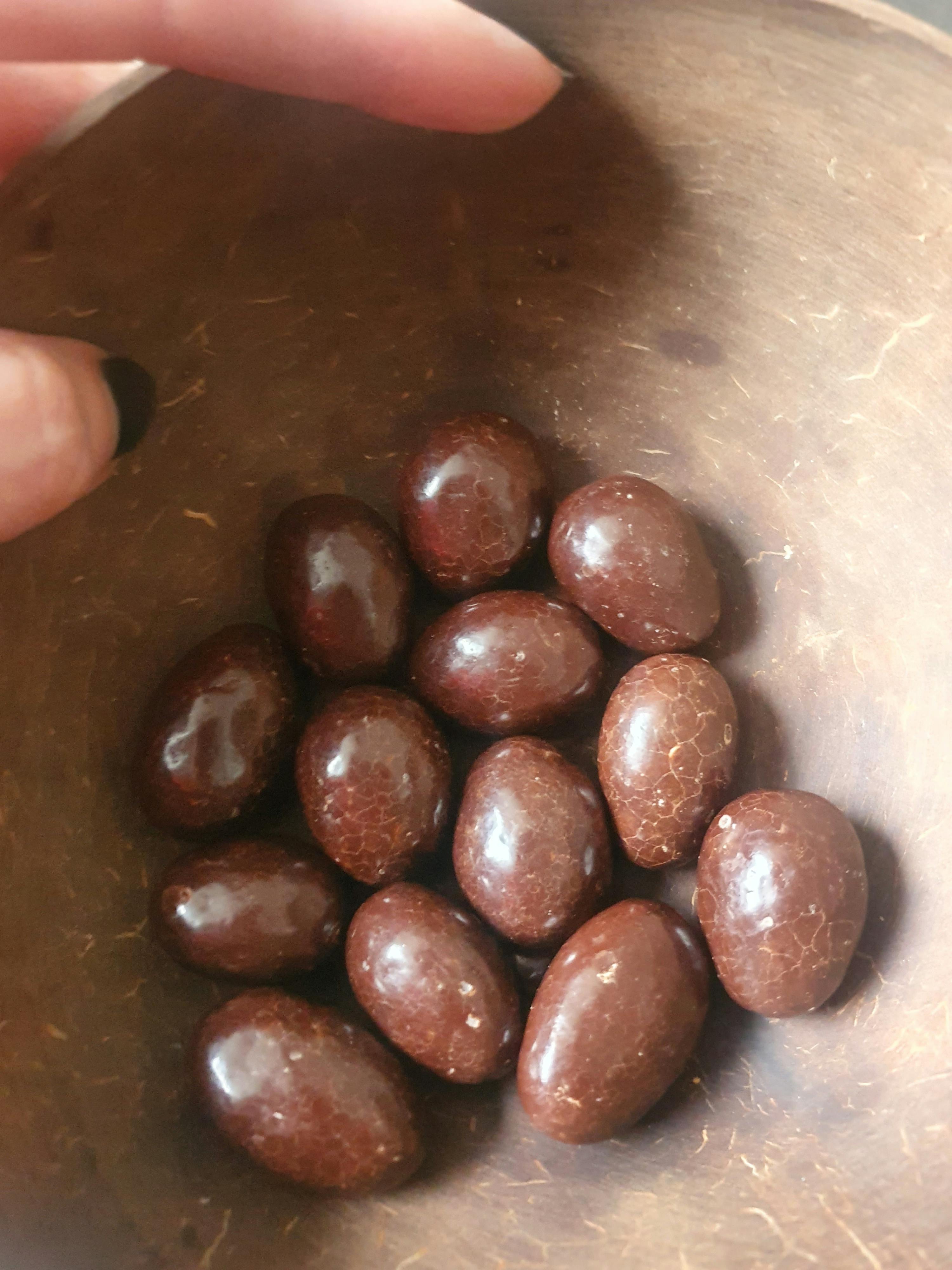 eine Person hält eine Schüssel mit Schokoladenbeeren in der Hand