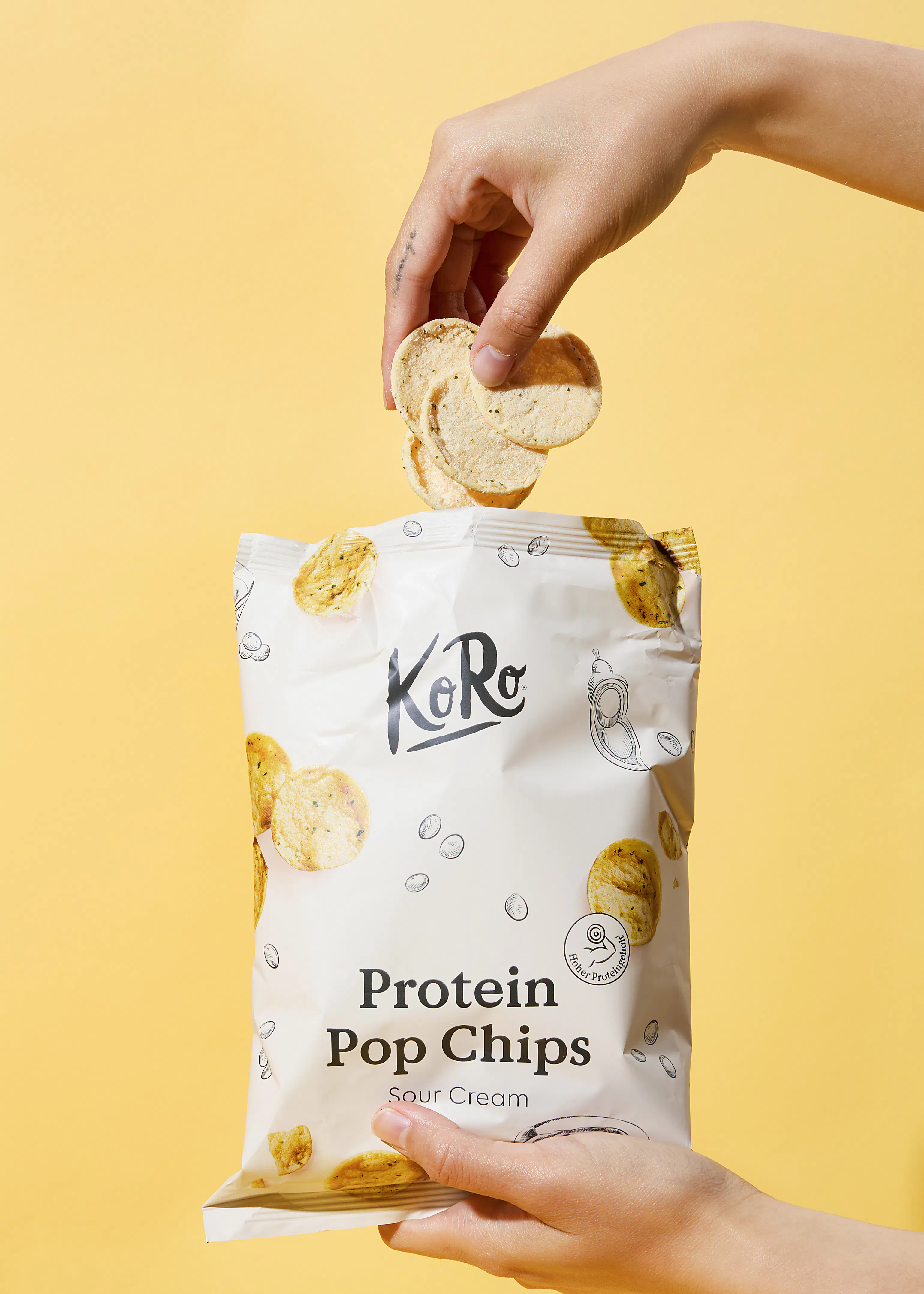 une personne tient un sac de chips de pop protéinées