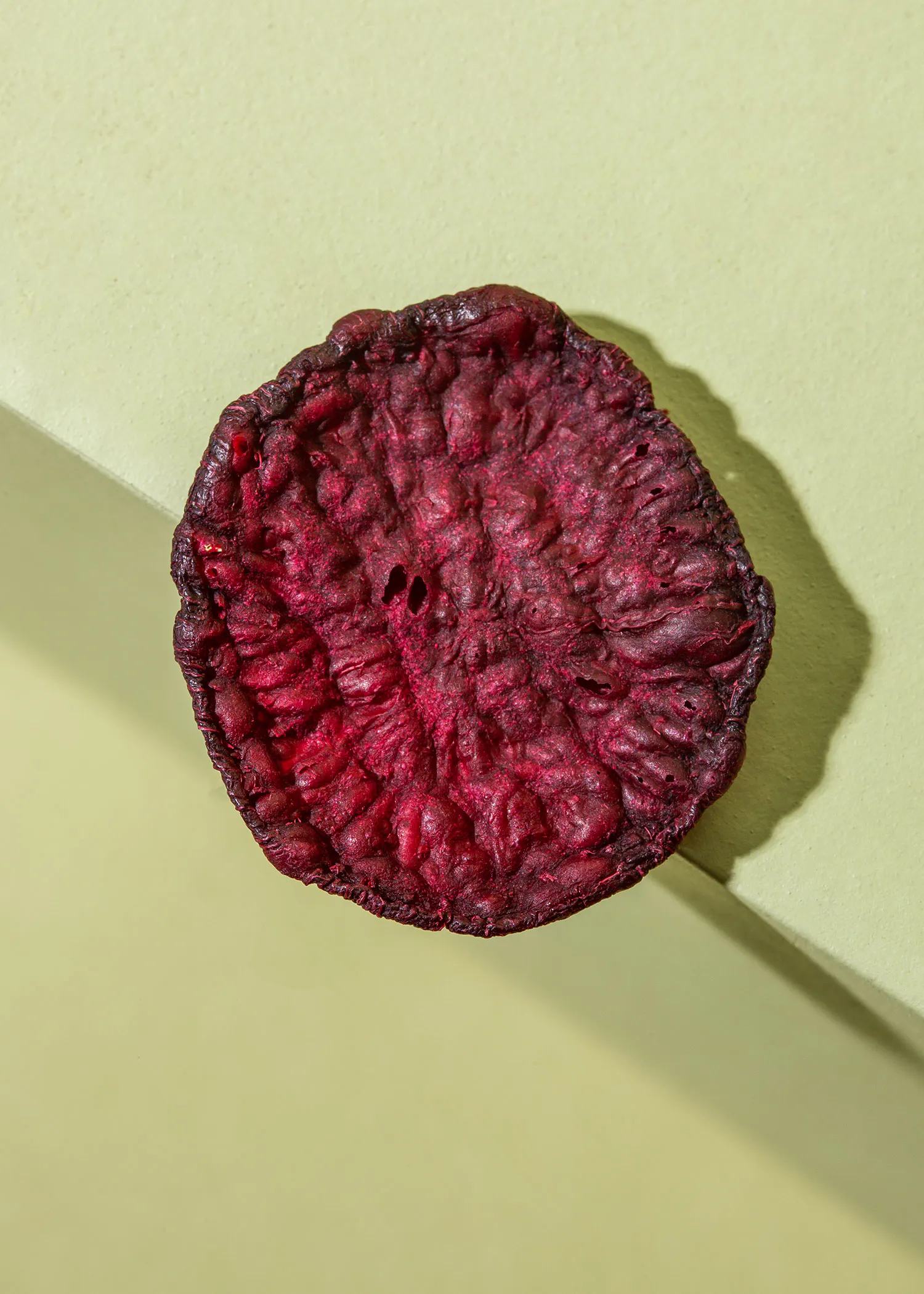a close up of a slice of beet on a green surface