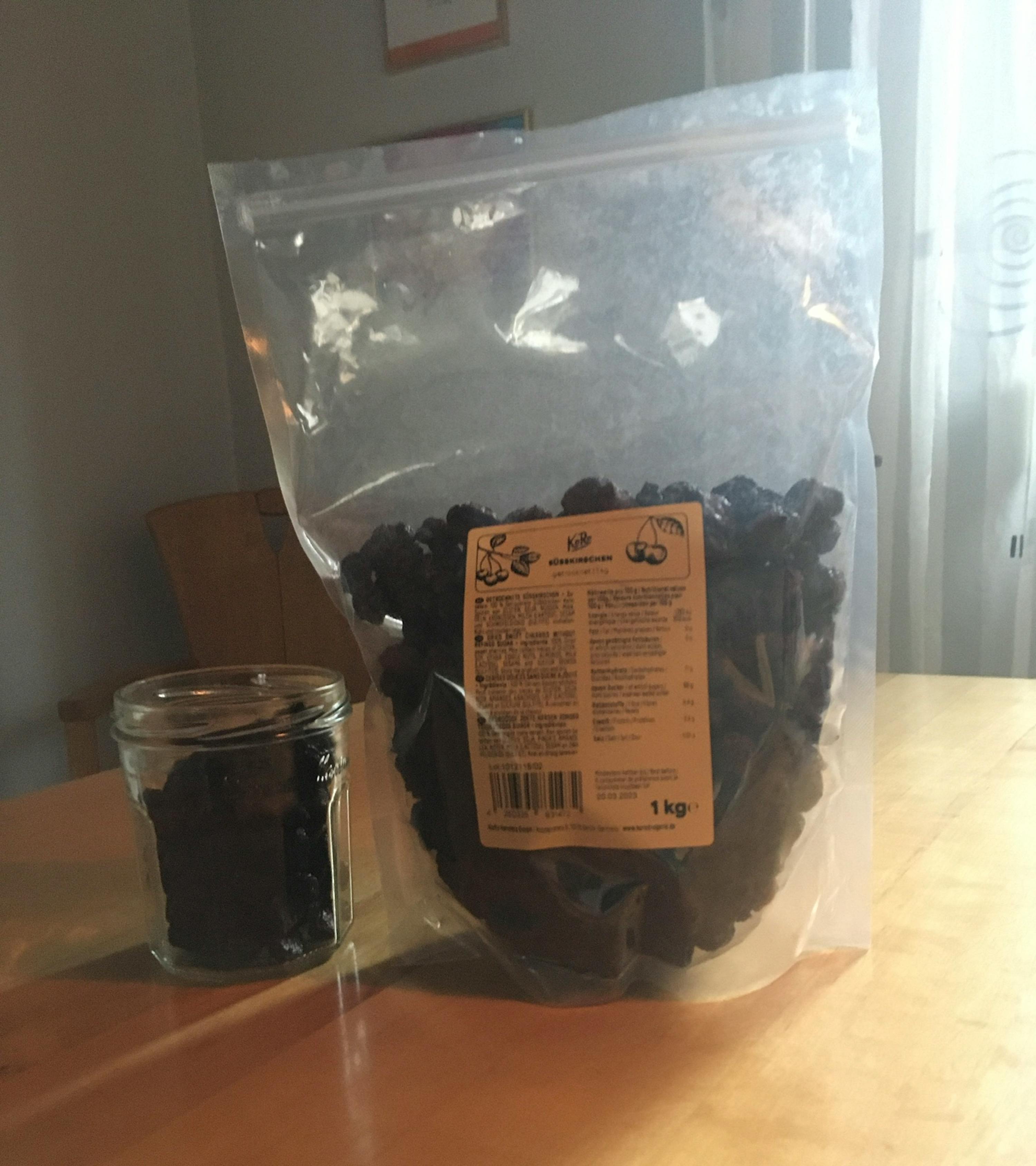 un sac de raisins secs est assis sur une table à côté d' un bocal de raisins secs