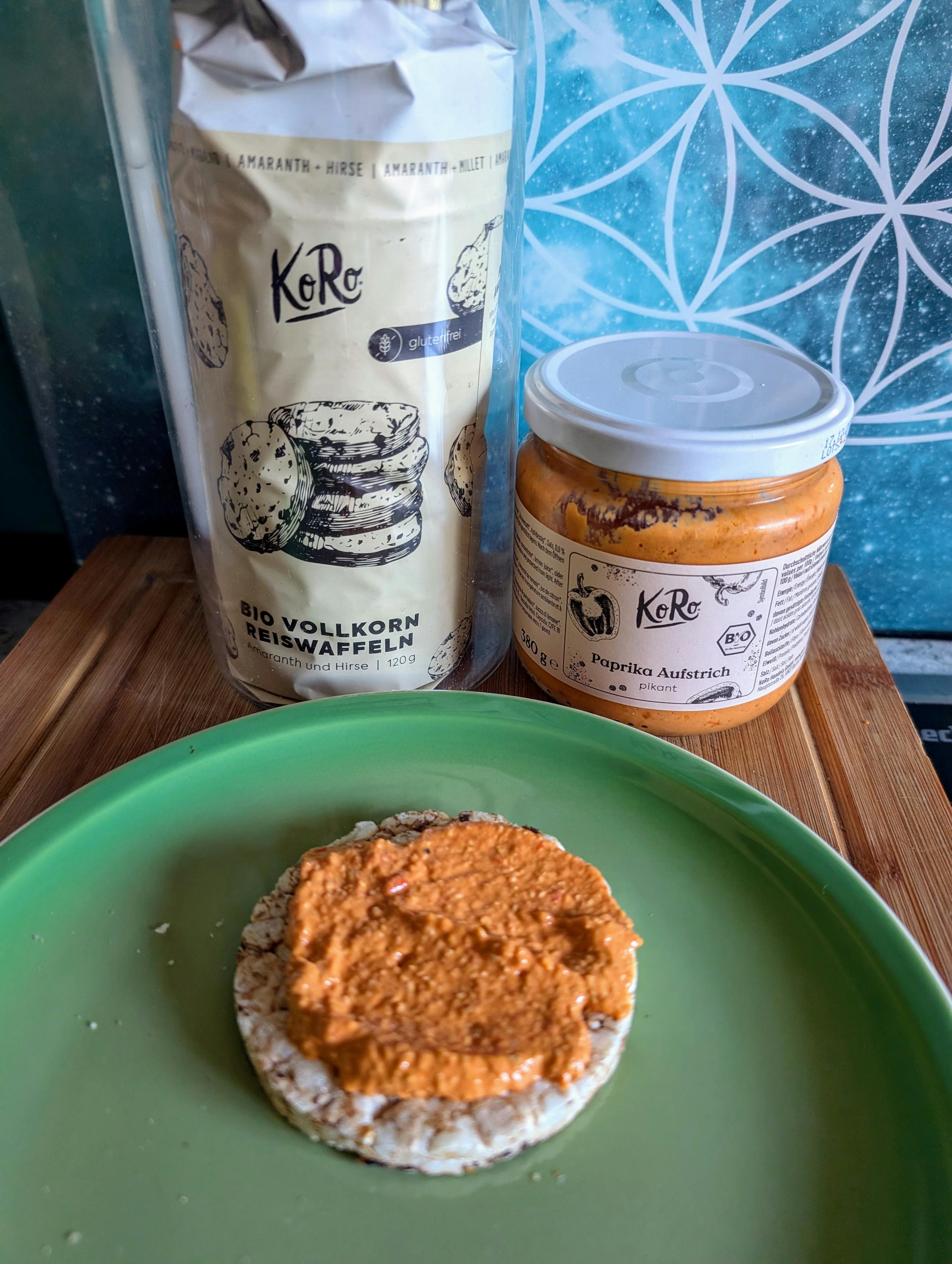 un piatto verde con una ciambella di riso e un barattolo di paprika