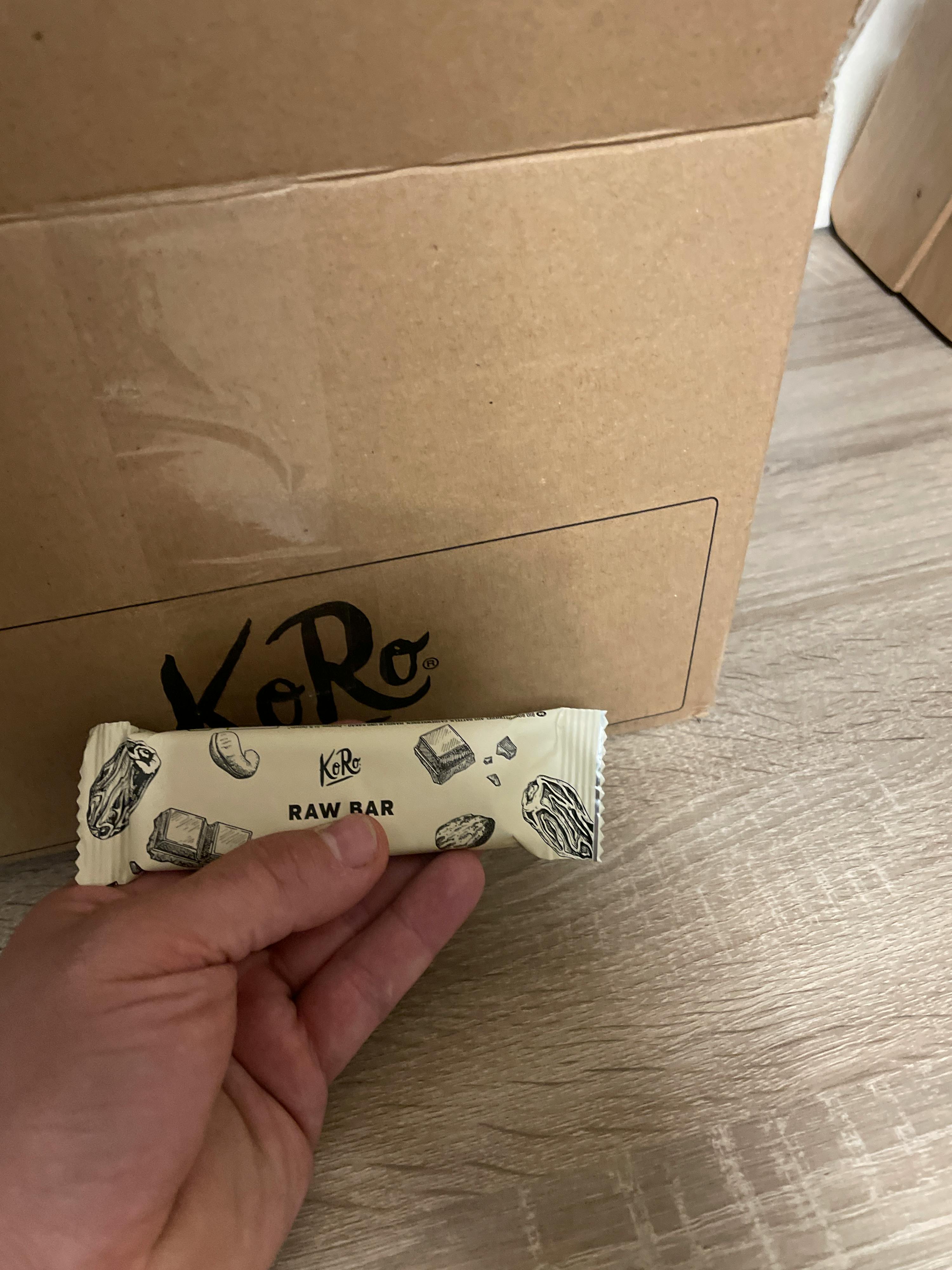une personne tient une barre de raw à côté d' une boîte en carton