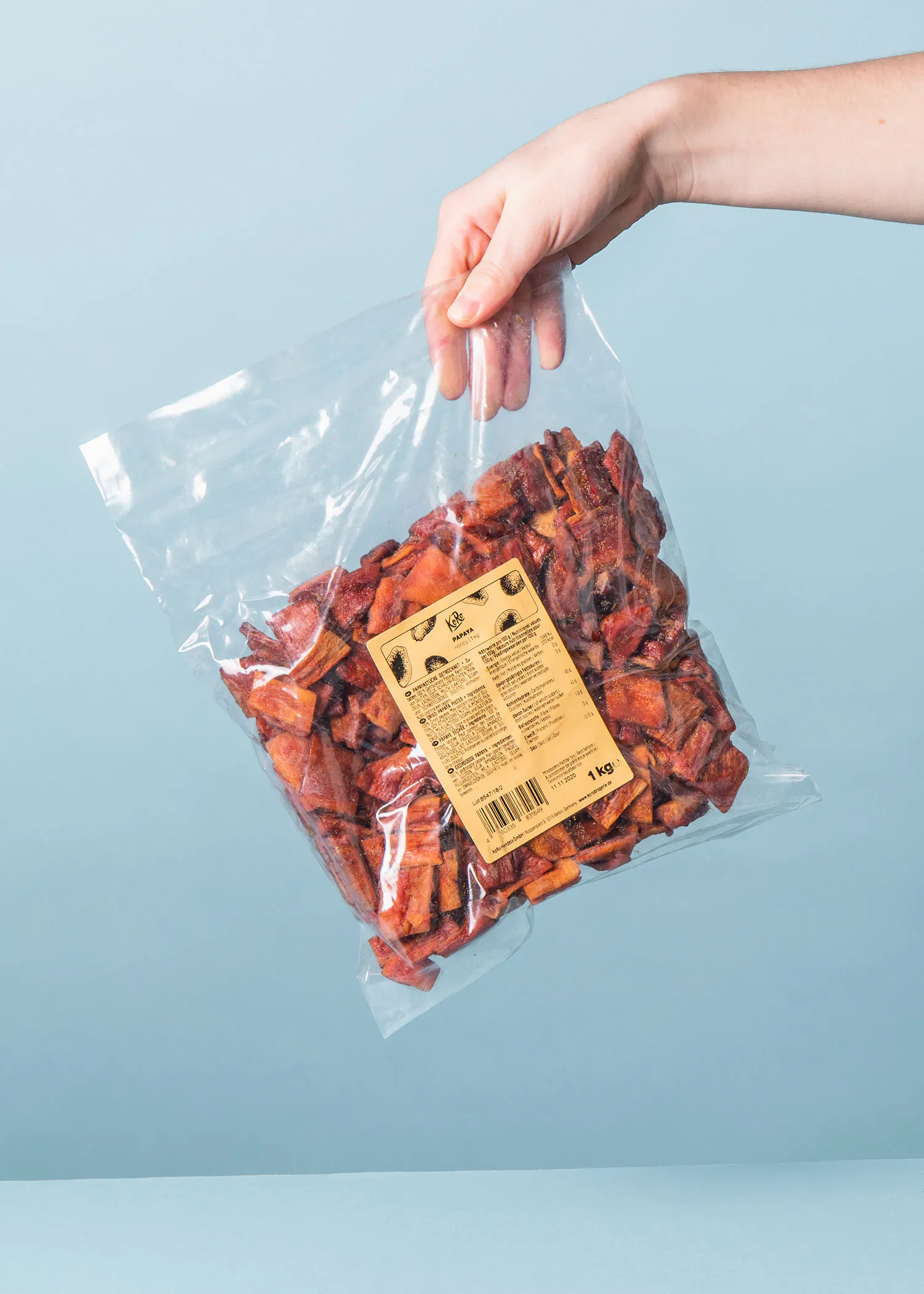 a person is holding a bag of dried fruit with a label that says 1 kg
