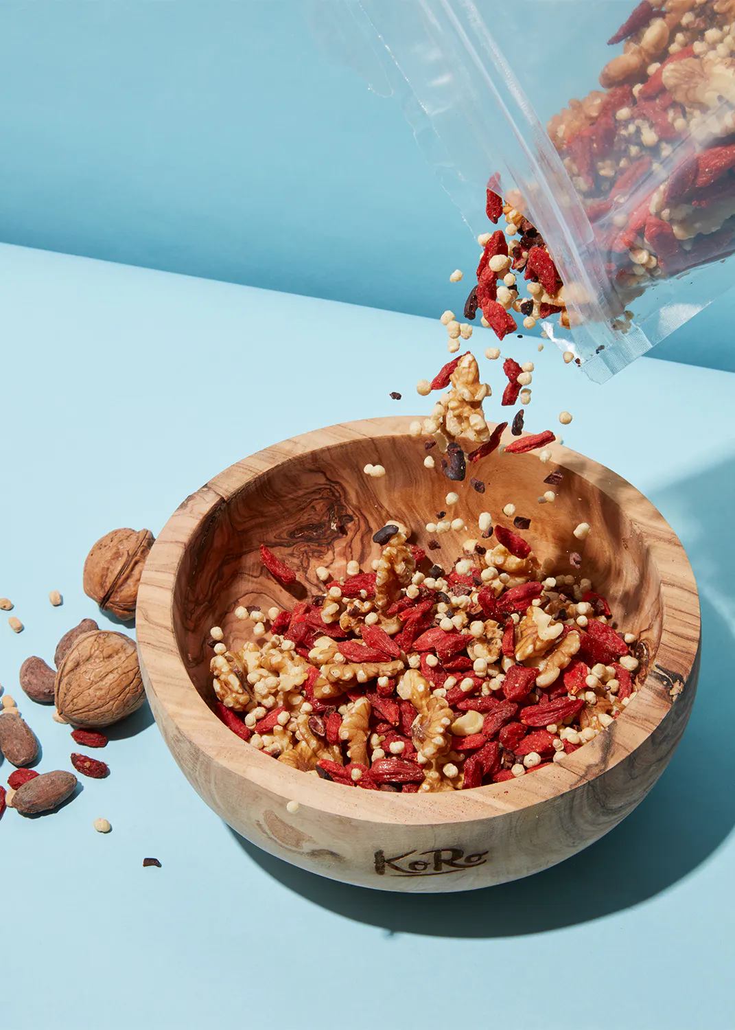 nuts and berries are poured into a wooden bowl that says kare