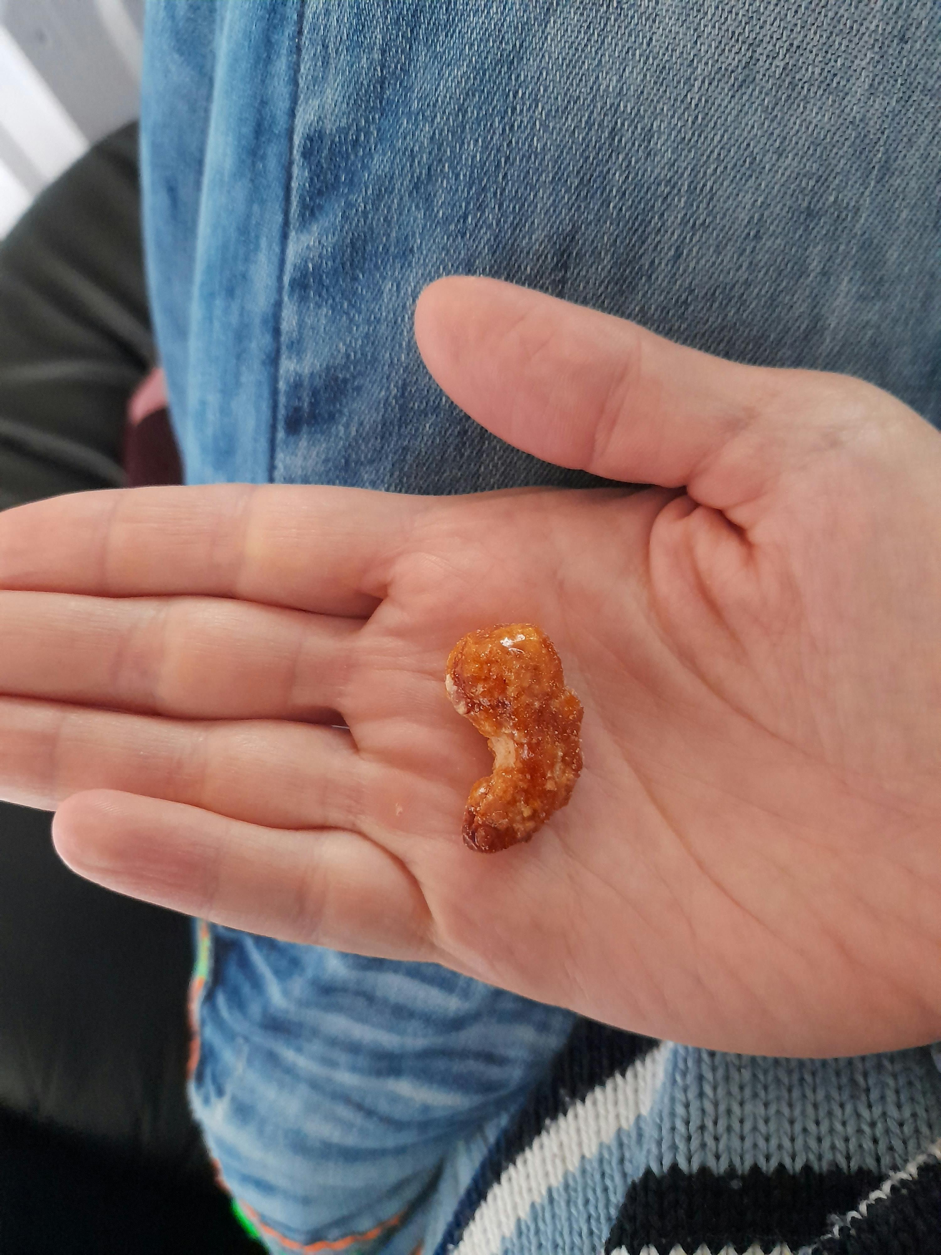 a person holding a small piece of food in their hand