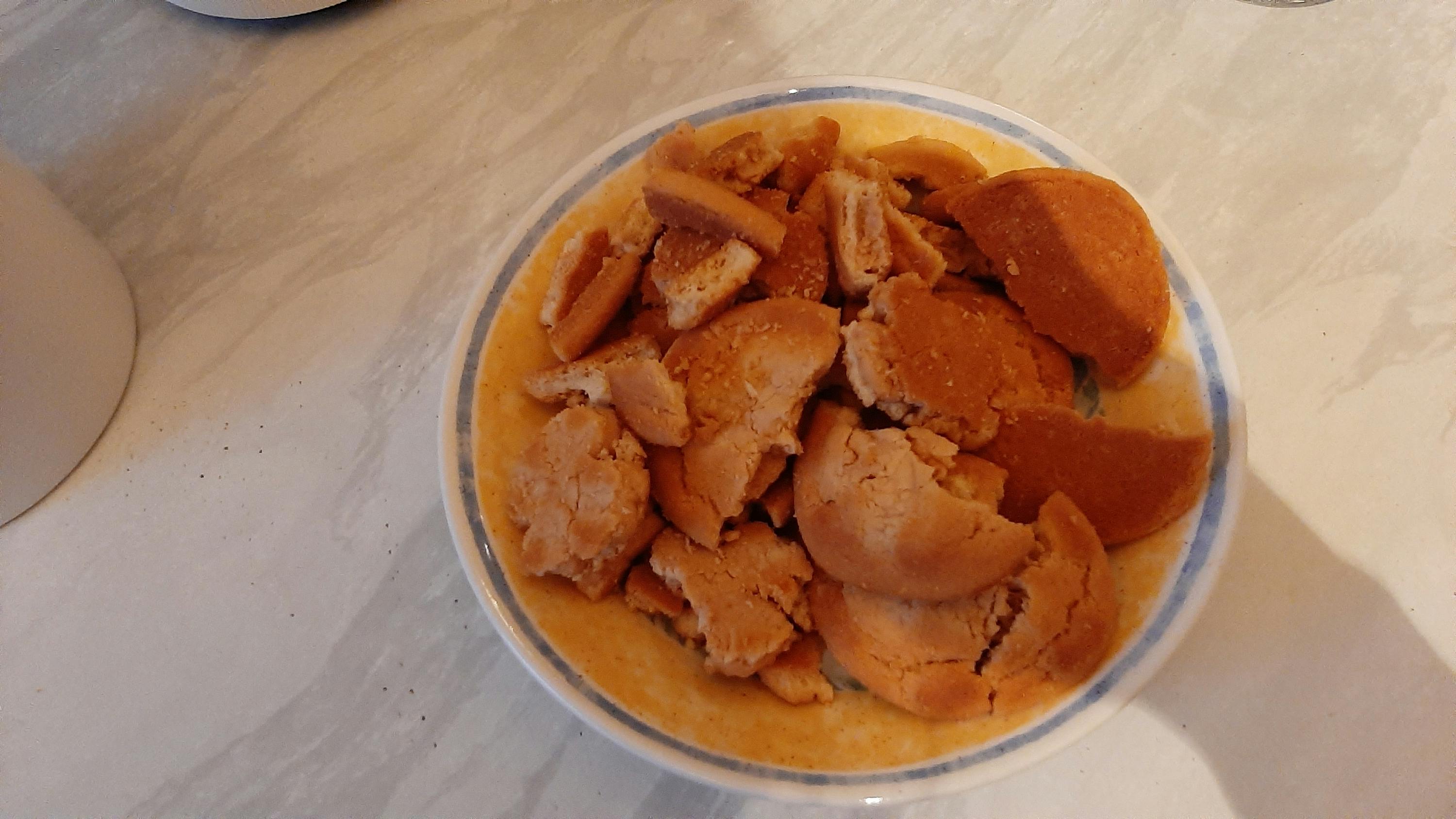 una ciotola piena di biscotti è seduta su un tavolo